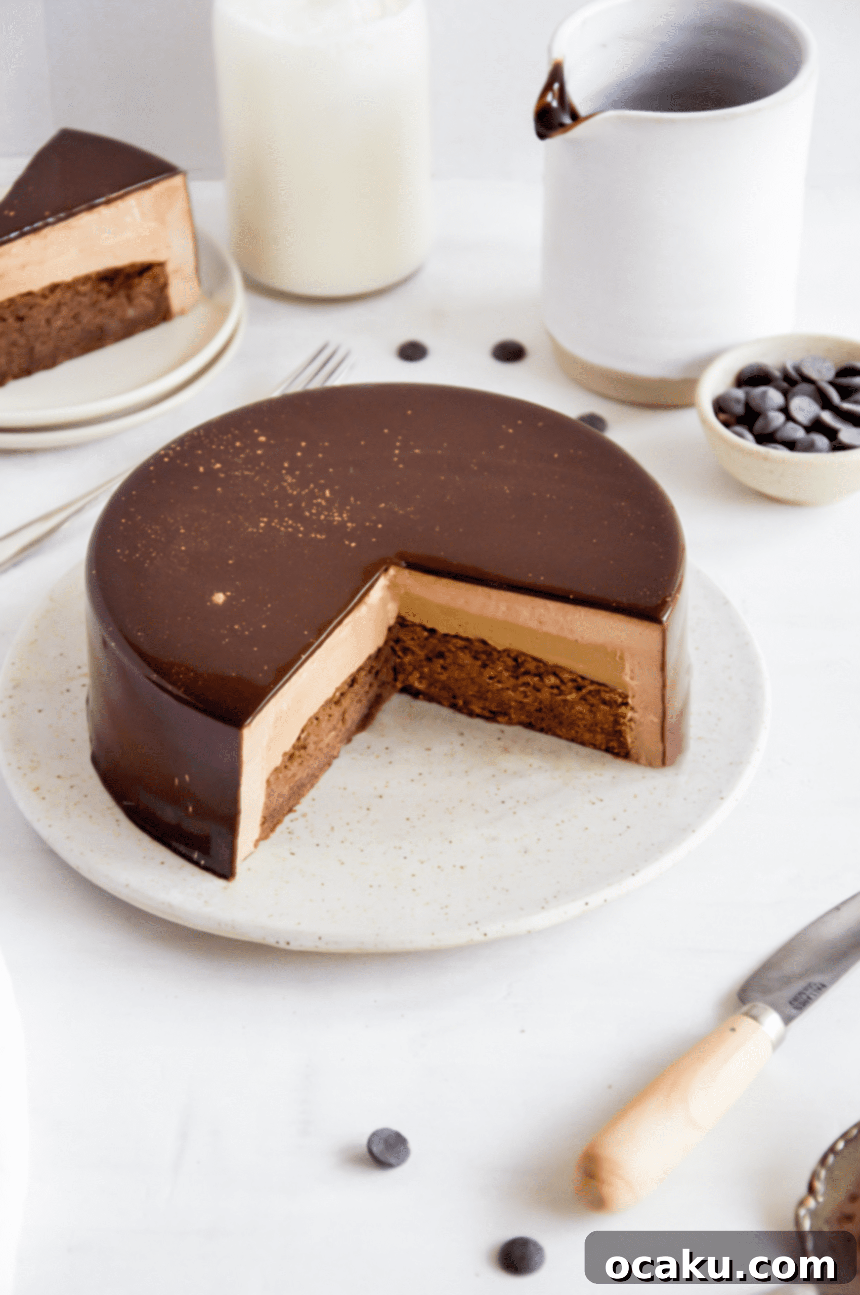 Close-up of the smooth, glossy mirror glaze and elegant detailing on the chocolate caramel mousse cake.