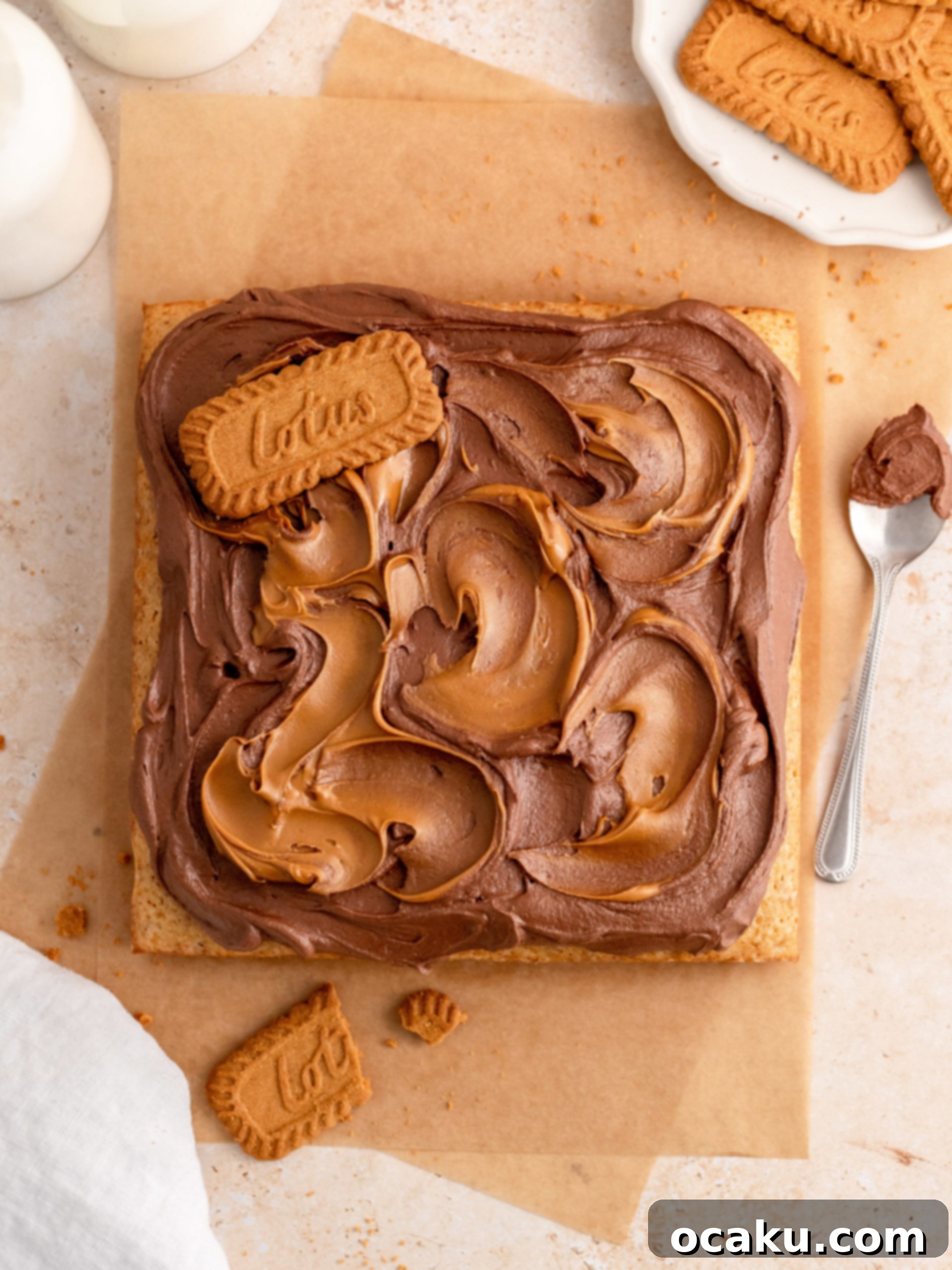 Biscoff Dream Cake 11 Step-by-step image showing dollops of Biscoff spread being swirled into the chocolate buttercream on the cake.