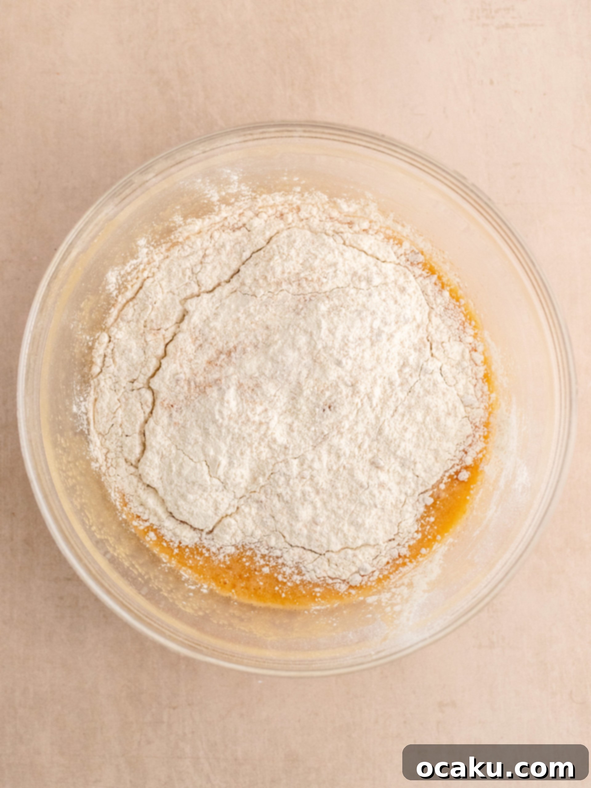 Biscoff Dream Cake 5 Step-by-step image showing Biscoff cake batter poured into a square baking pan.