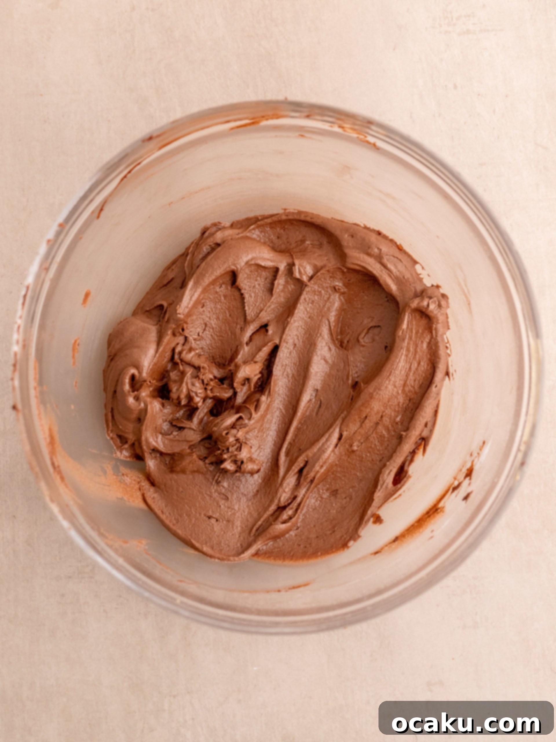 Biscoff Dream Cake 10 Step-by-step image showing chocolate buttercream being spread onto the Biscoff cake.