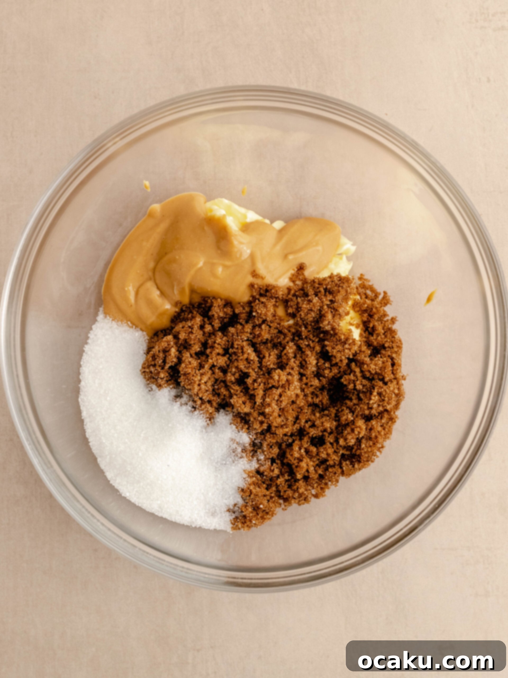 Nutella Peanut Butter Swirl Cookies 4 A bowl containing brown sugar, granulated sugar, smooth peanut butter, and softened butter, ready to be creamed.