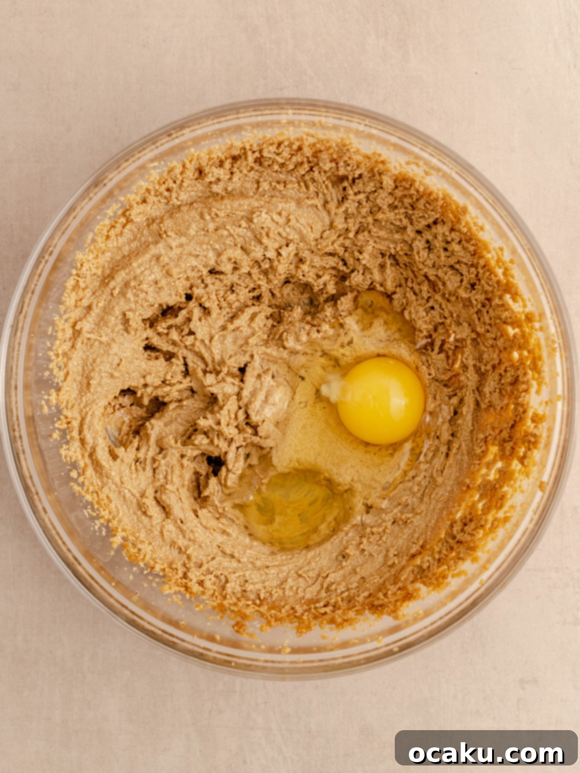 Nutella Peanut Butter Swirl Cookies 5 A mixture of creamed butter, sugars, and peanut butter, with an egg and vanilla extract just added, ready for mixing.