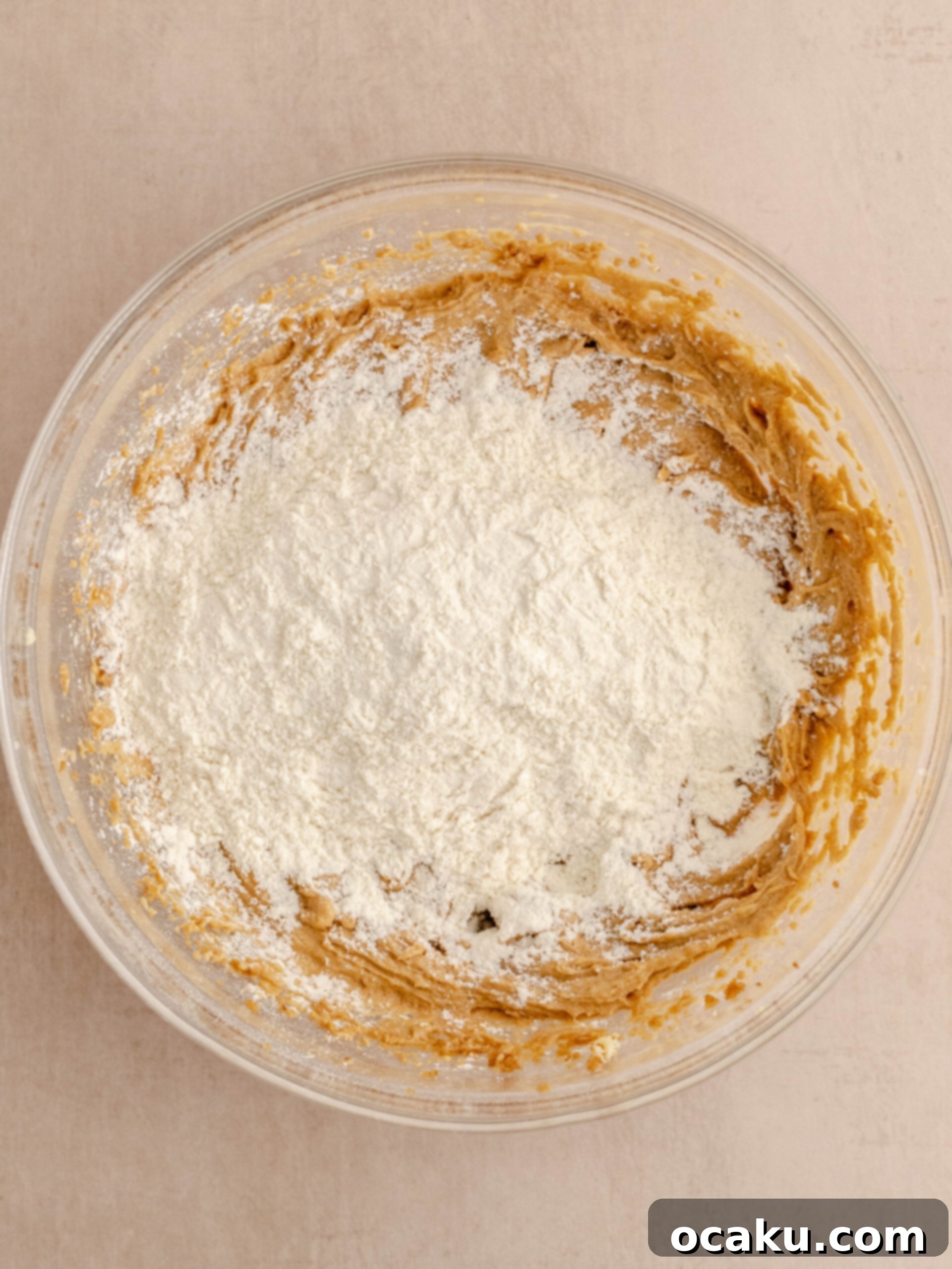 Nutella Peanut Butter Swirl Cookies 6 Dry flour mixture being gently folded into the wet ingredients to form cookie dough.