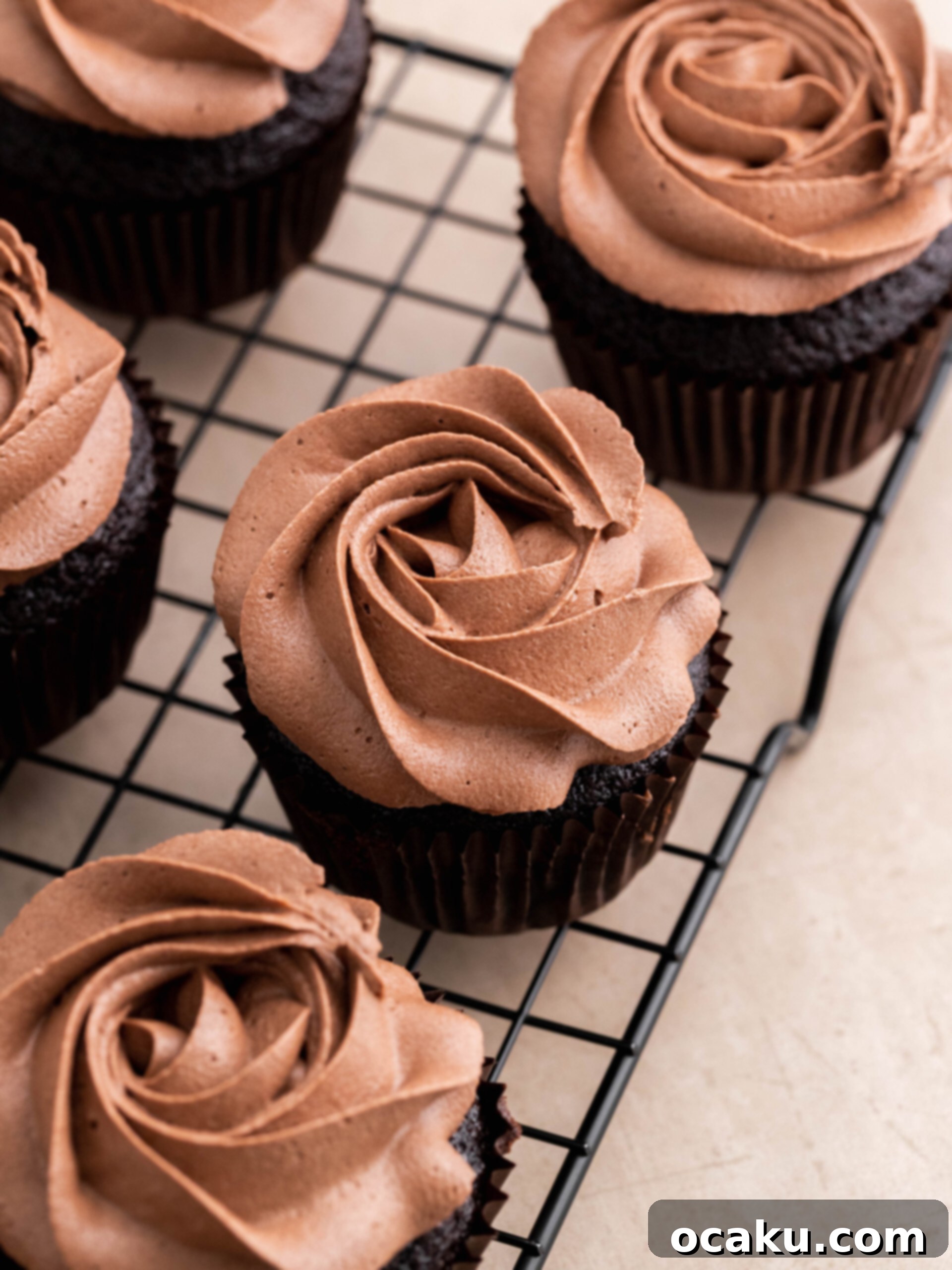 Finished Nutella cupcakes decorated with buttercream, a dollop of Nutella, and chopped hazelnuts.