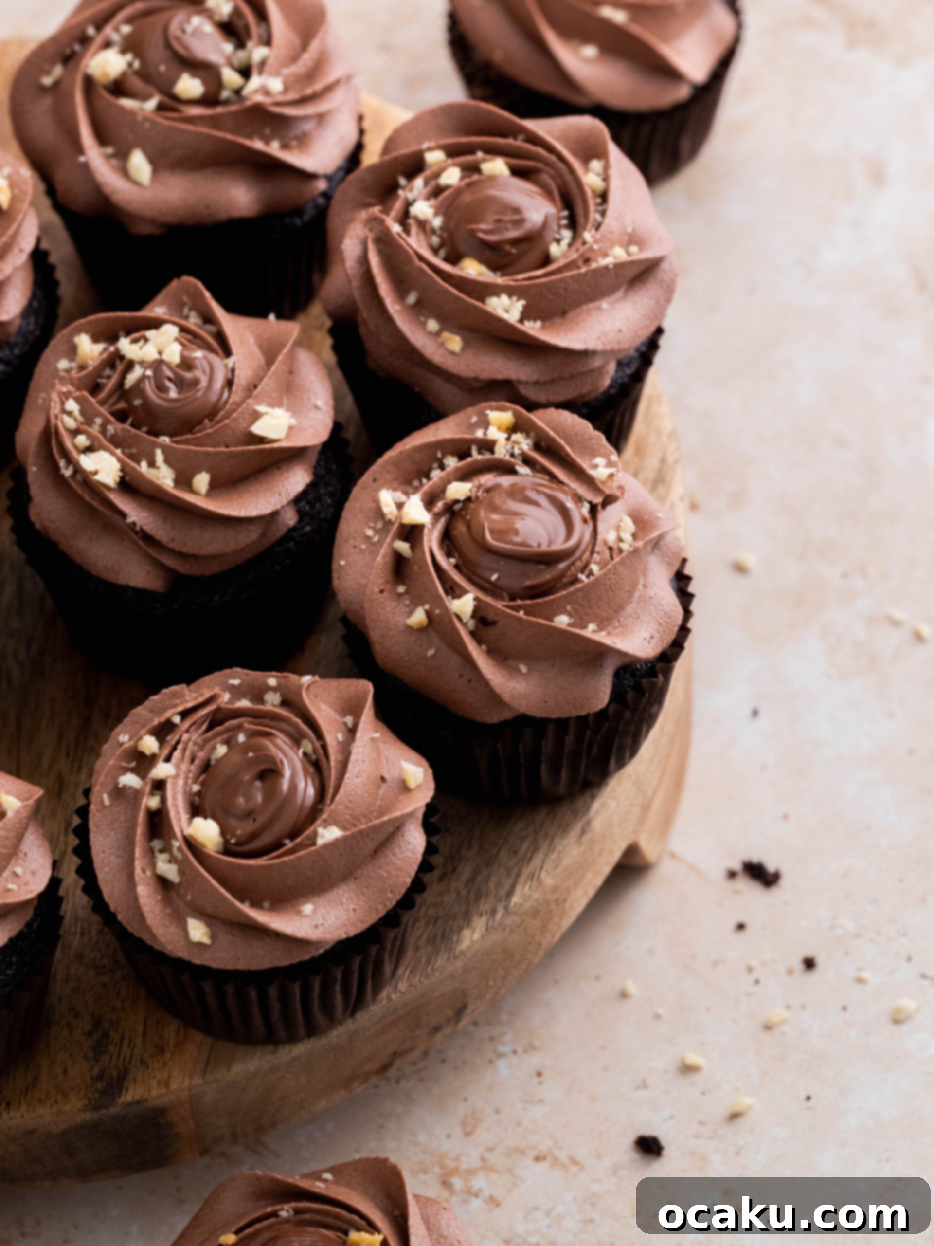 Decorated Nutella cupcake with generous Nutella buttercream and chopped hazelnuts on top.