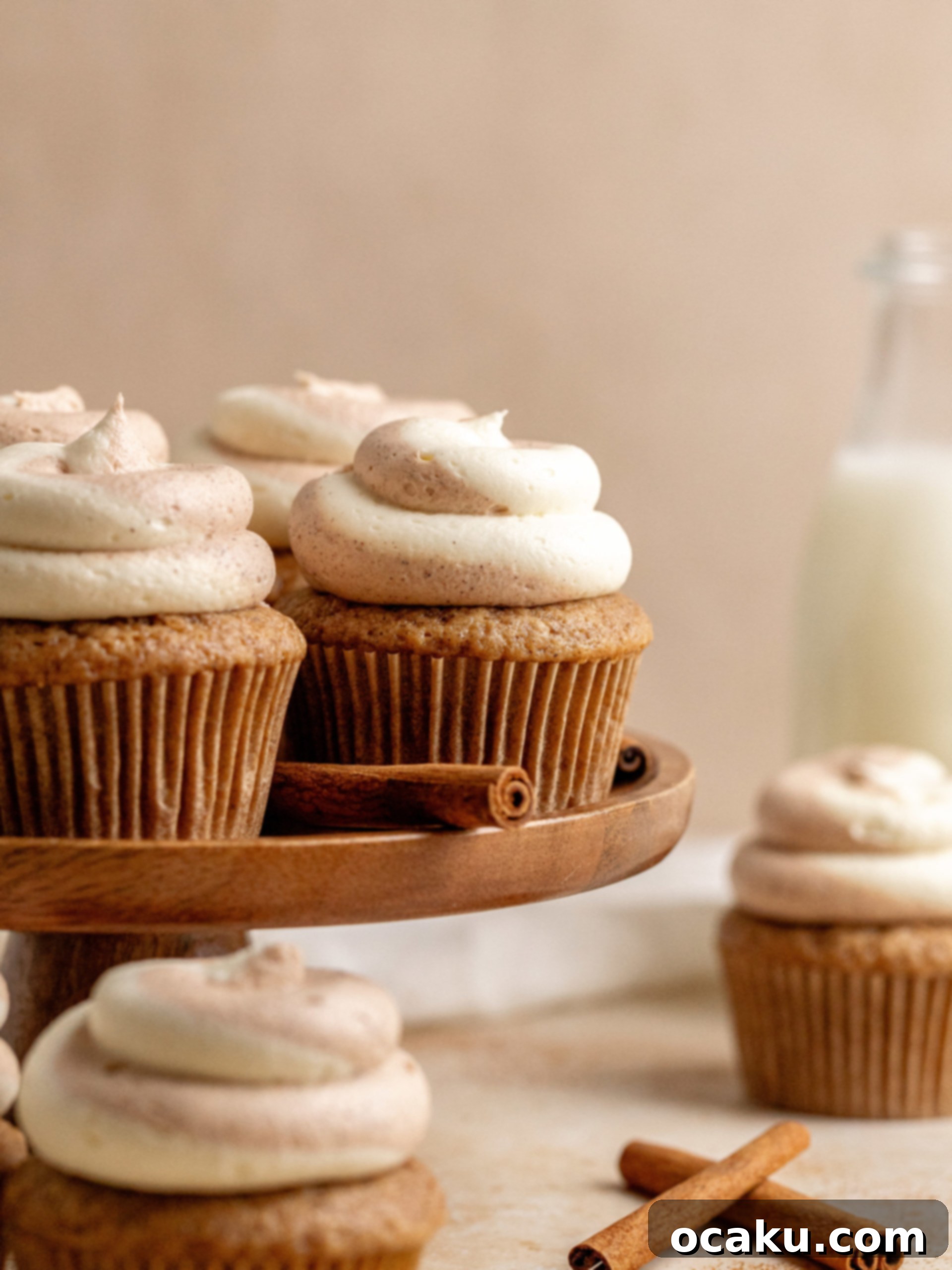 Decadent Cinnamon Cupcakes 10 A close-up shot of a cupcake being frosted with swirled vanilla and cinnamon buttercream.