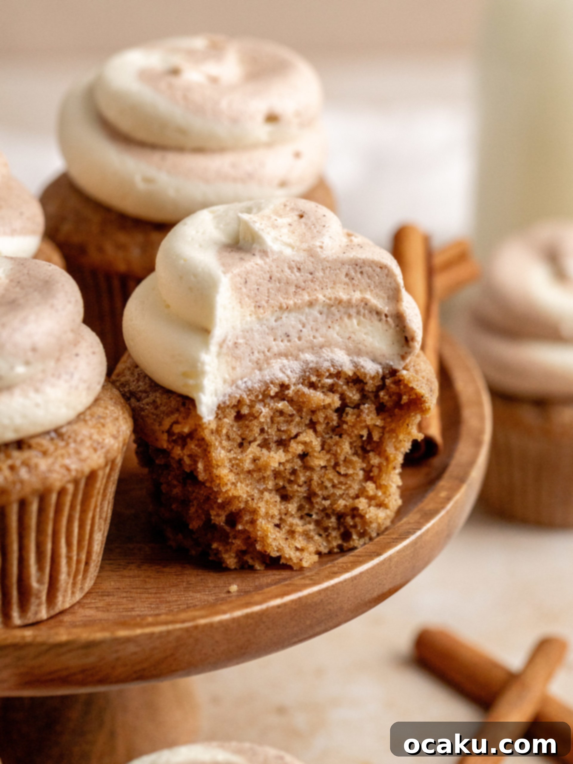 Decadent Cinnamon Cupcakes 12 A top-down view of several frosted cinnamon cupcakes, beautifully arranged on a rustic wooden surface.