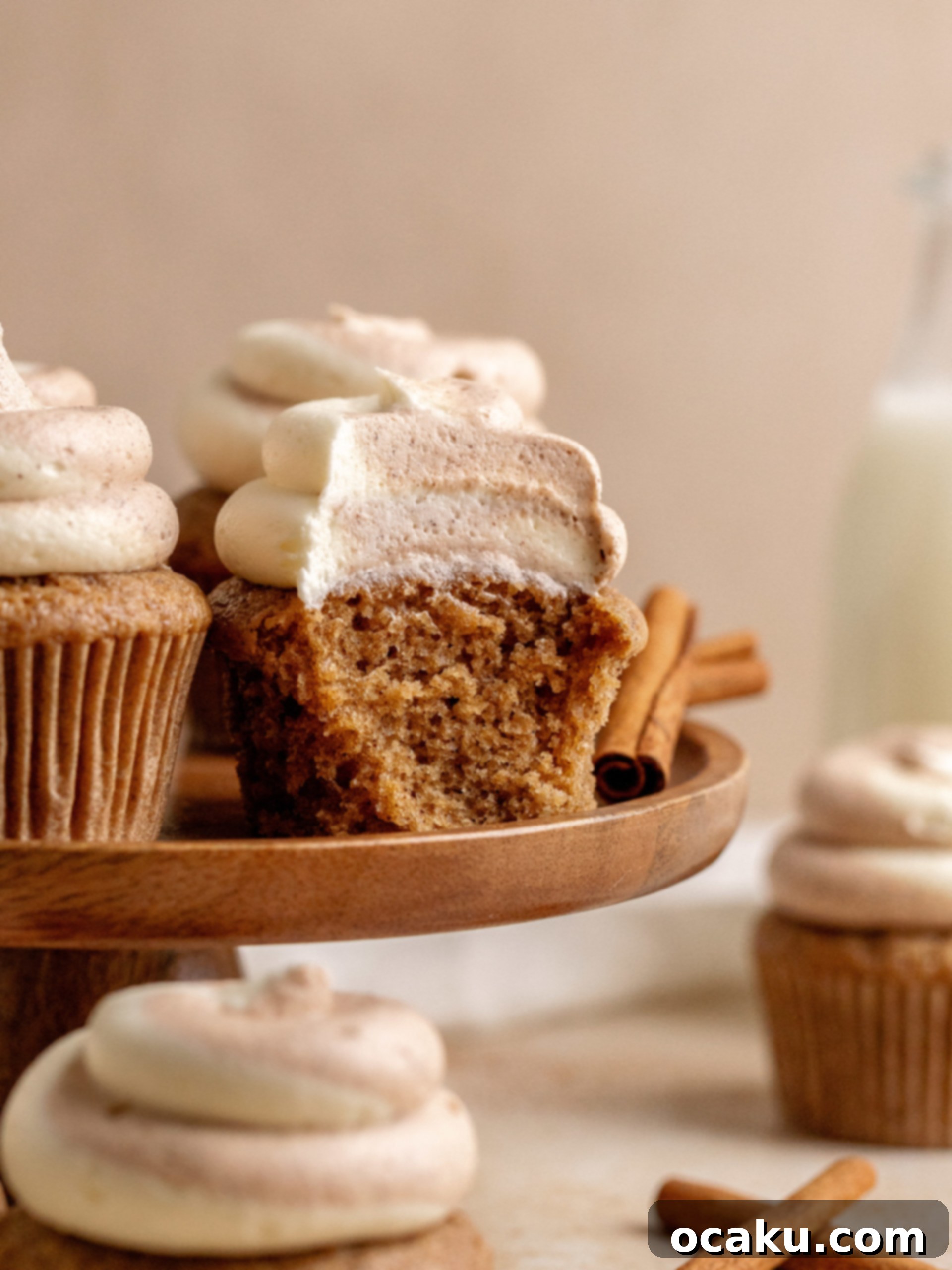 Aperol Spritz Cheesecake Close-up of a stack of fluffy, un-frosted cinnamon cupcakes on a cooling rack, showcasing their golden-brown tops.