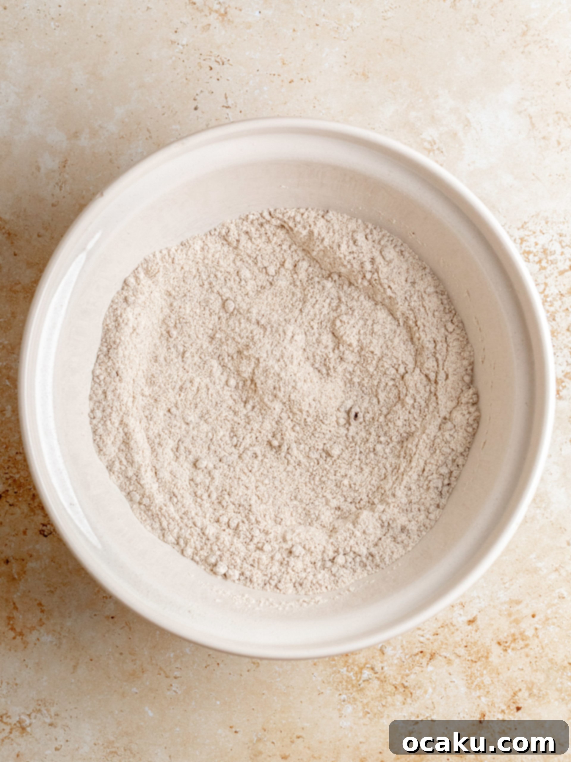 Decadent Cinnamon Cupcakes 3 Dry ingredients for cupcakes, including flour, sugar, and cinnamon, neatly arranged in a bowl.