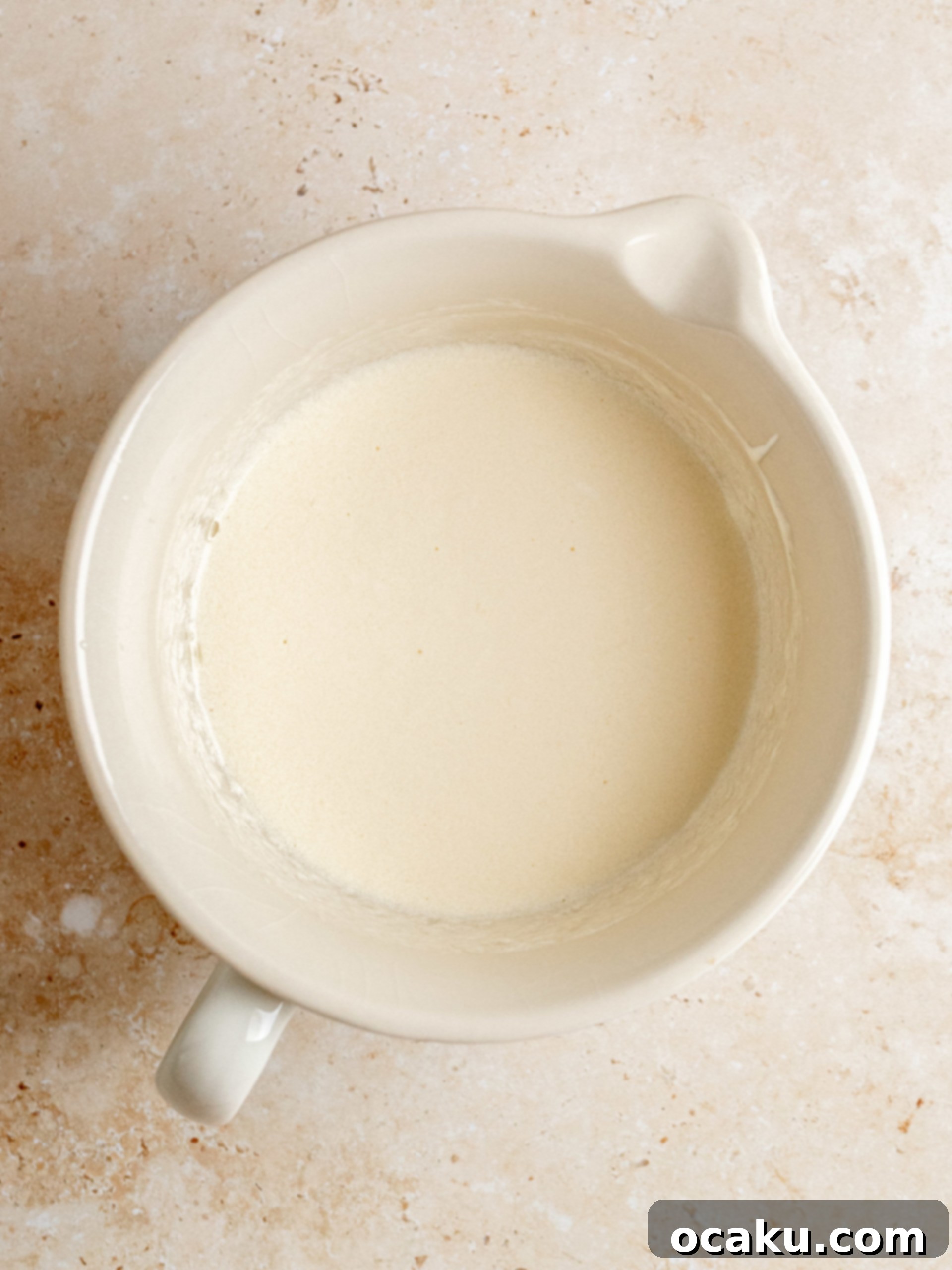 Decadent Cinnamon Cupcakes 4 Wet ingredients for cupcakes, like eggs, oil, and sour cream, mixed in a separate bowl.