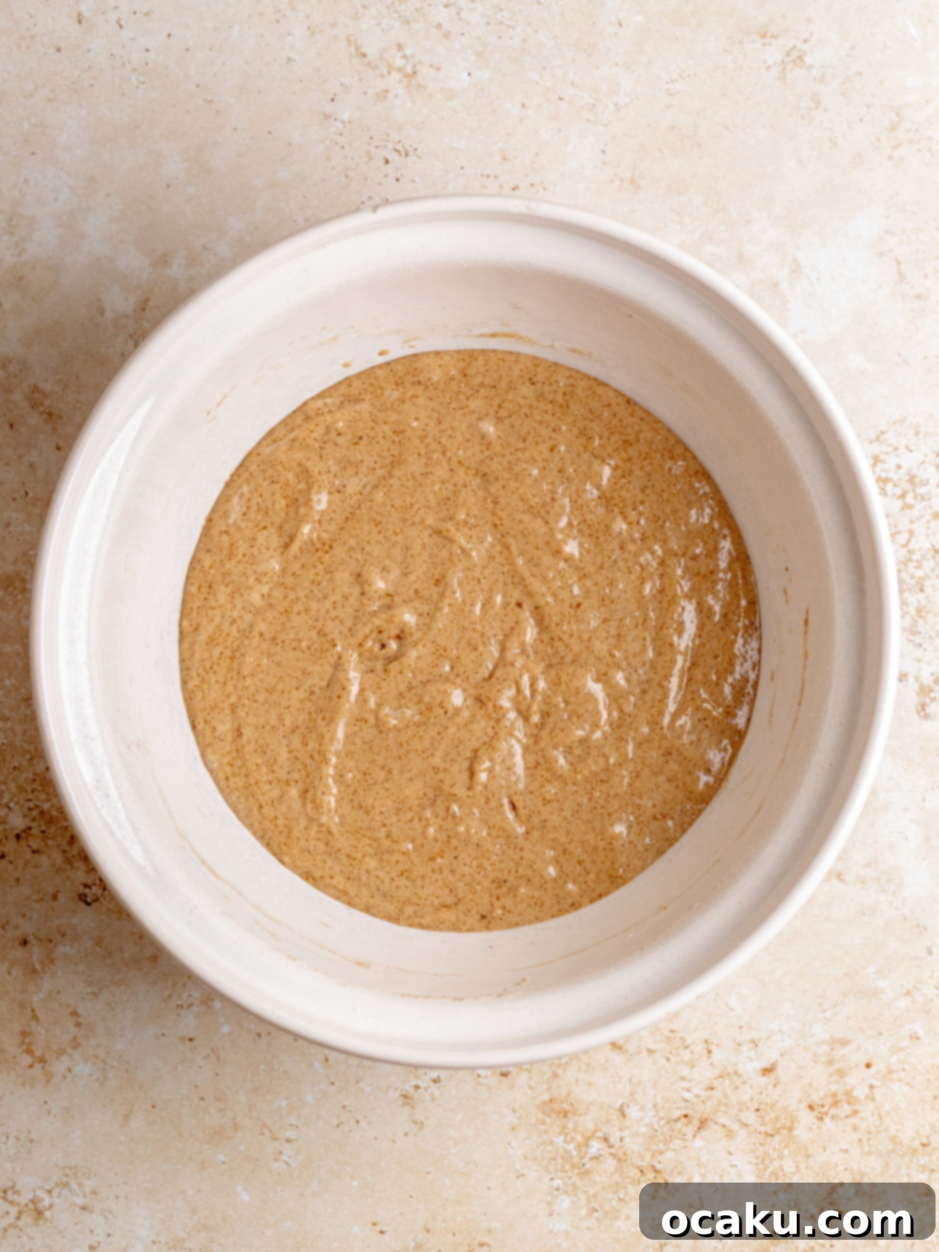 Decadent Cinnamon Cupcakes 5 Cupcake batter being gently stirred in a bowl, showcasing its smooth consistency.