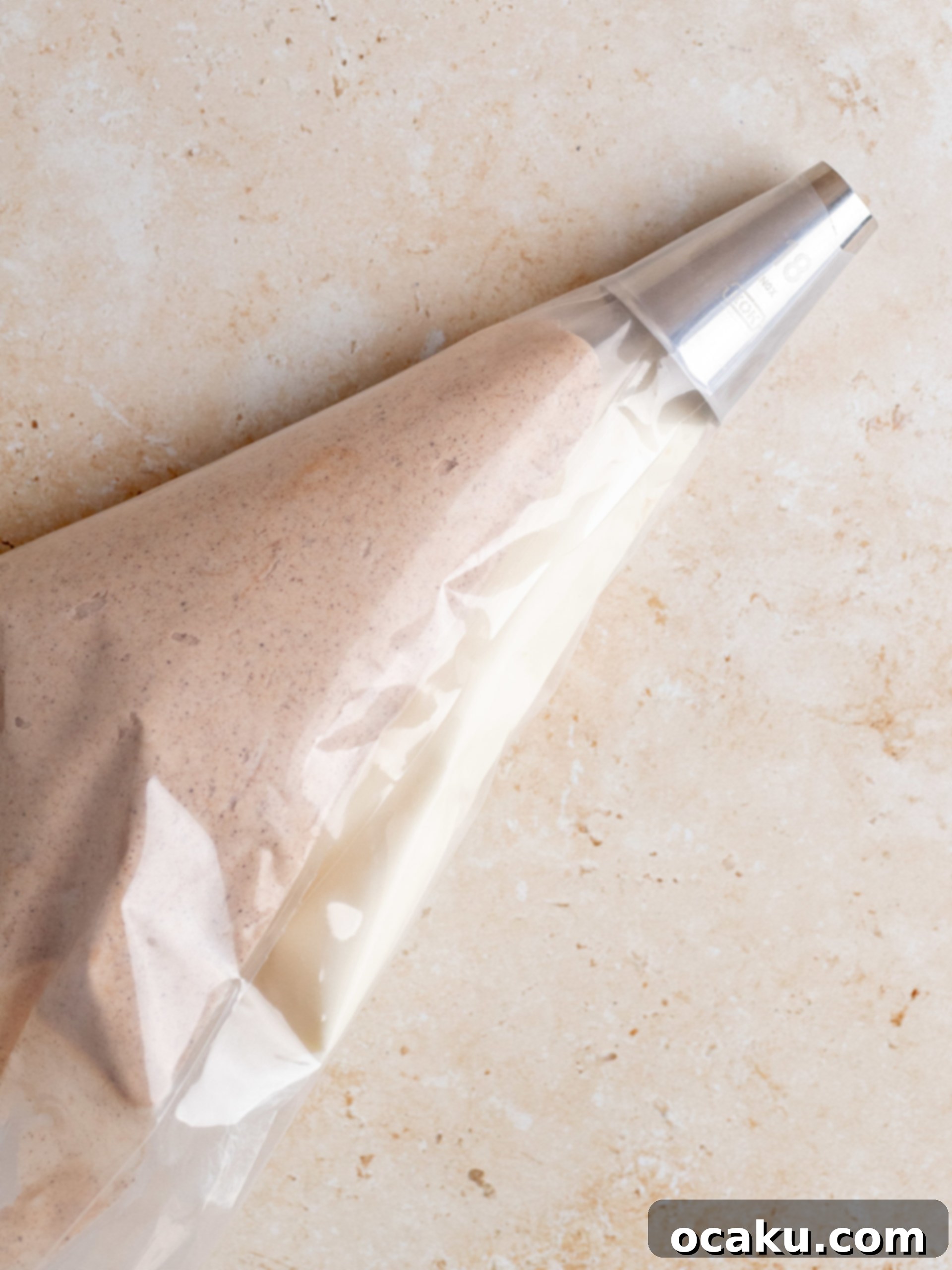 Decadent Cinnamon Cupcakes 9 One piping bag filled with vanilla buttercream, another with cinnamon buttercream, side-by-side.