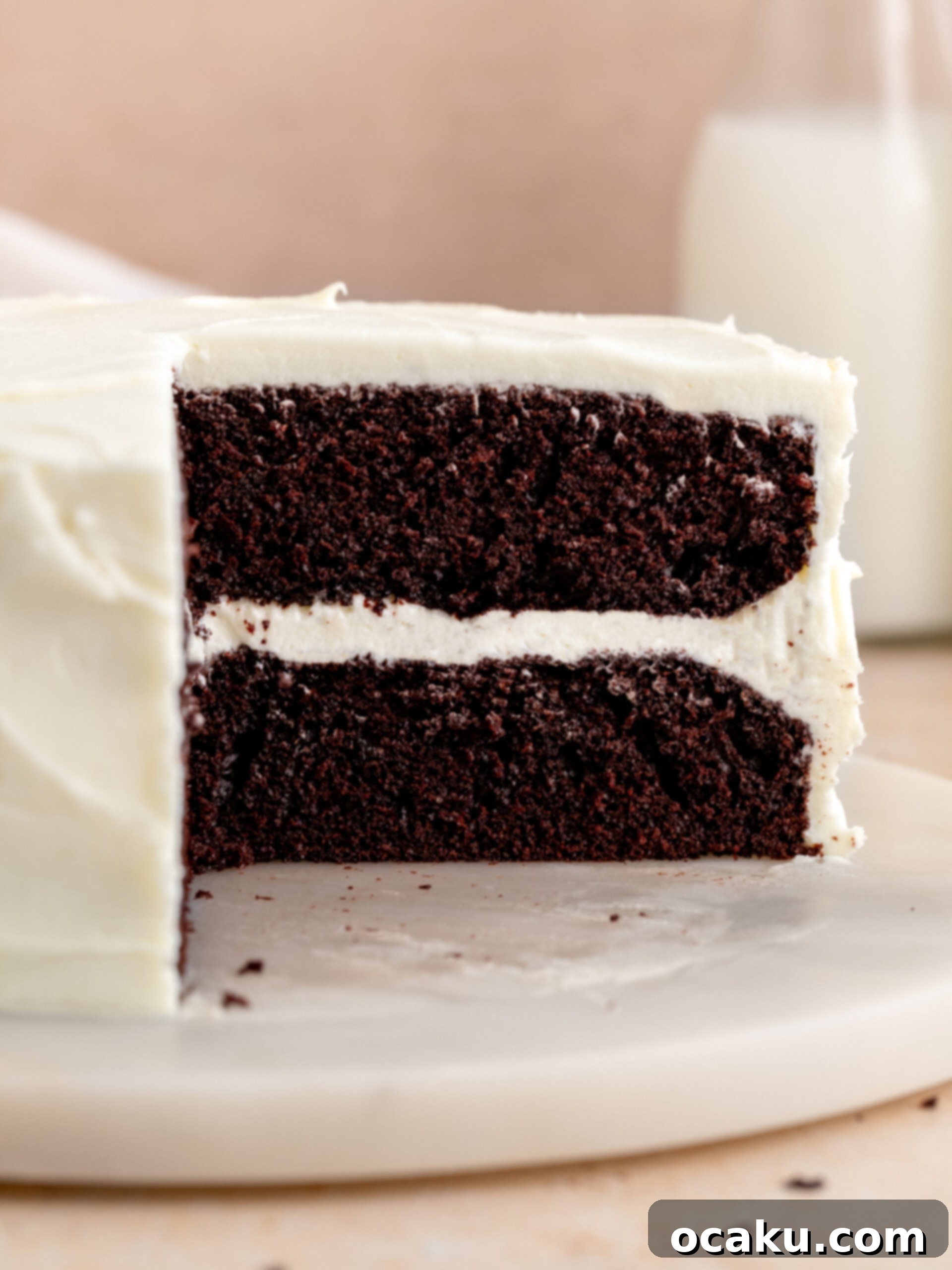 Chocolate cake with cream cheese frosting on a cake stand, elegantly decorated.