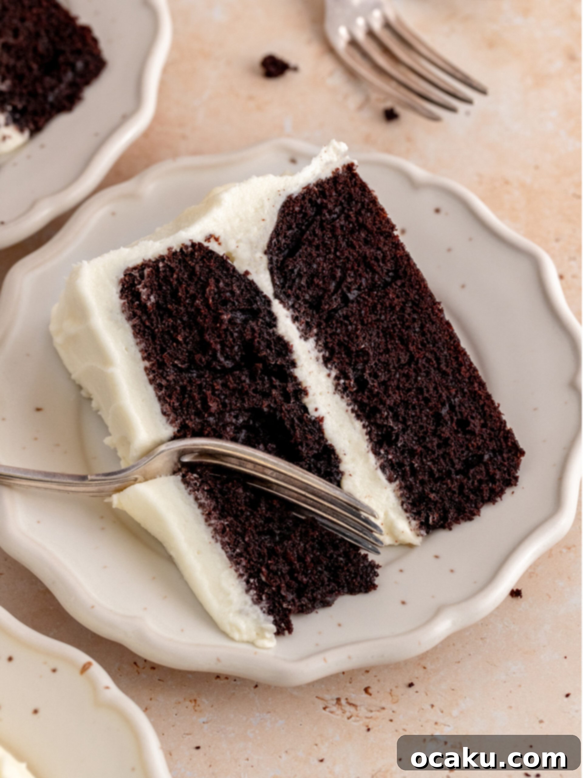 A perfect slice of chocolate cake with cream cheese frosting on a plate, ready to be enjoyed.