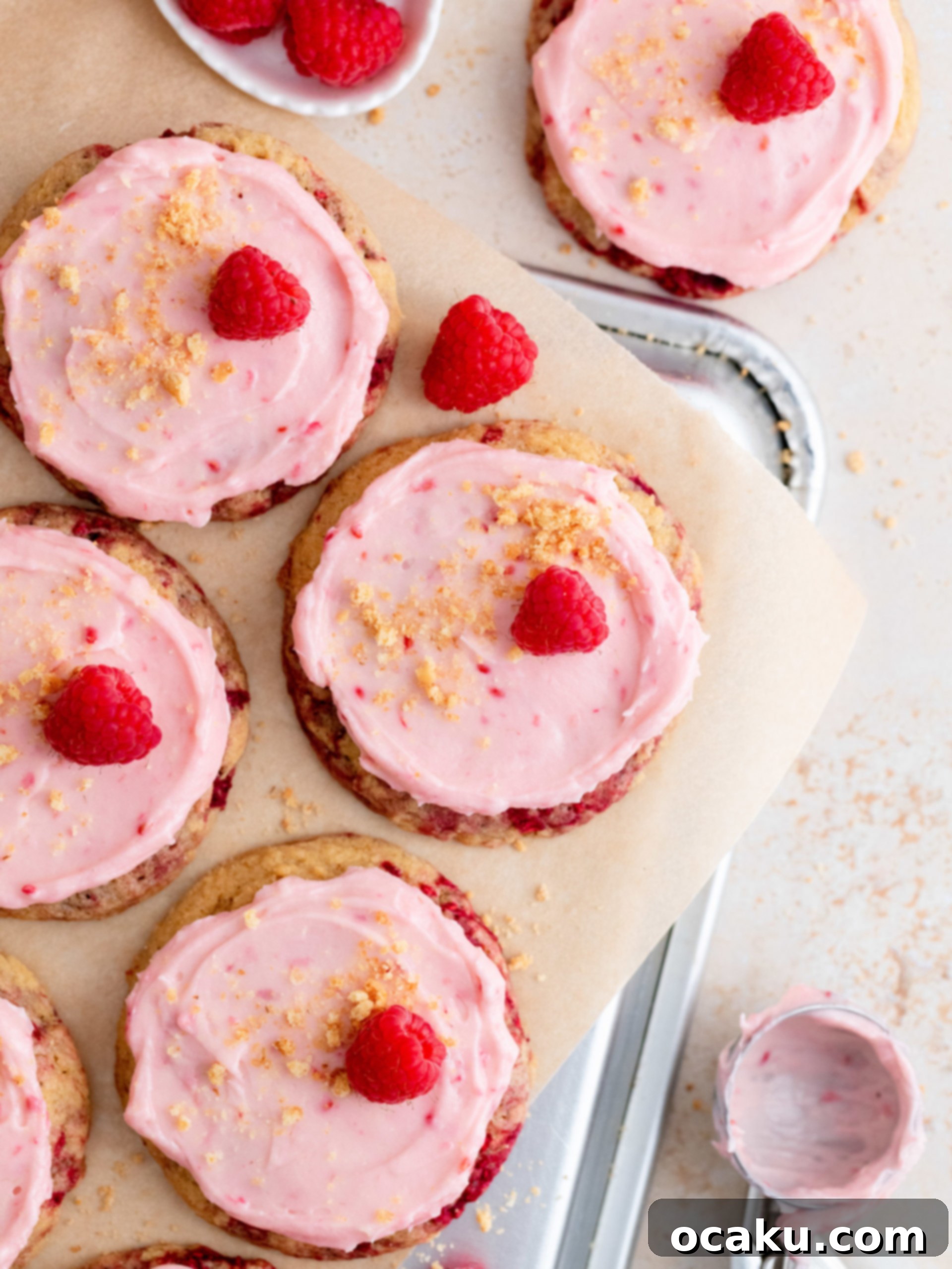 Close-up of baked raspberry cheesecake cookies on a cooling rack, showing the flat tops before frosting.