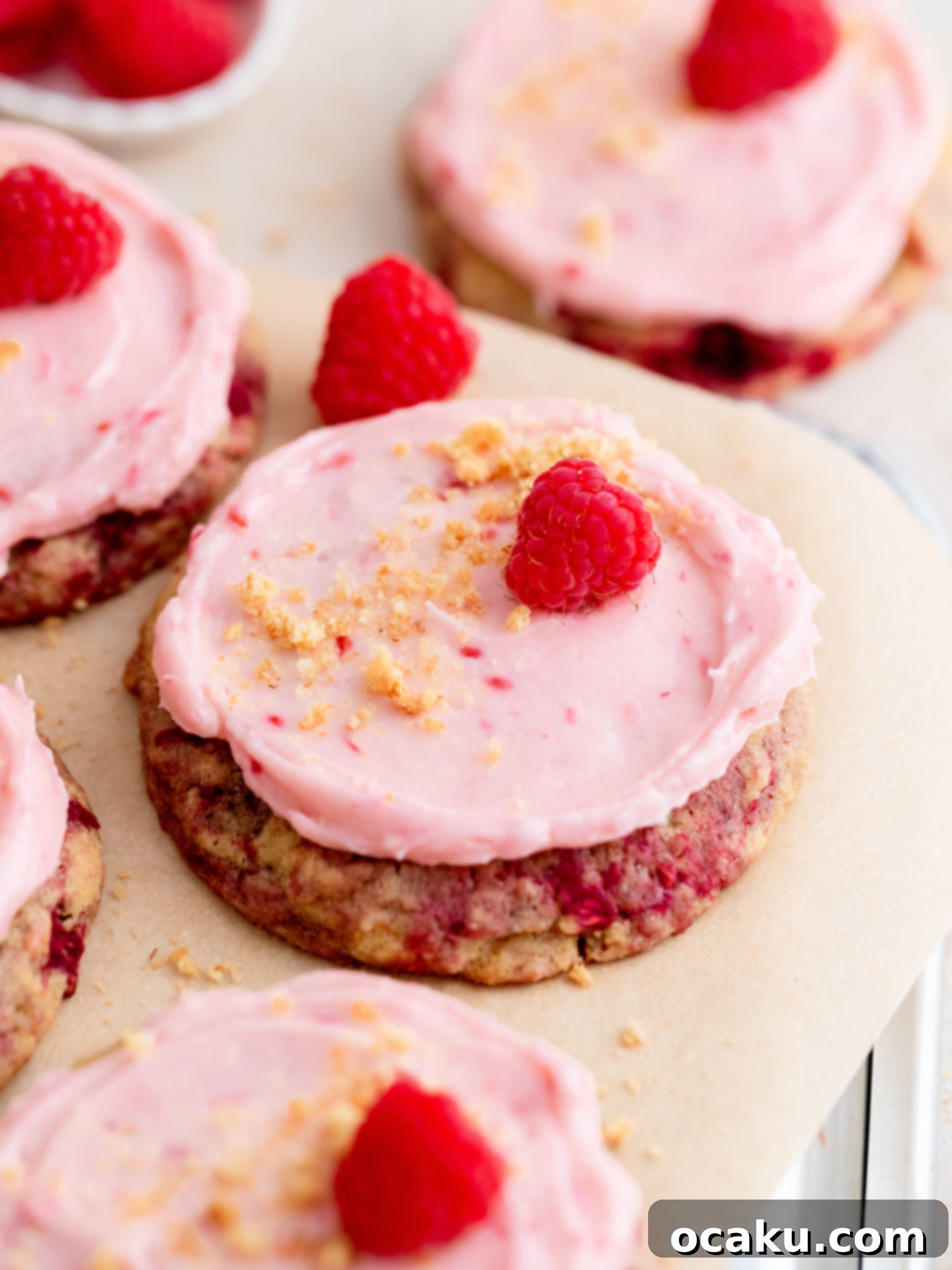 A perfectly frosted raspberry cheesecake cookie, ready to eat.