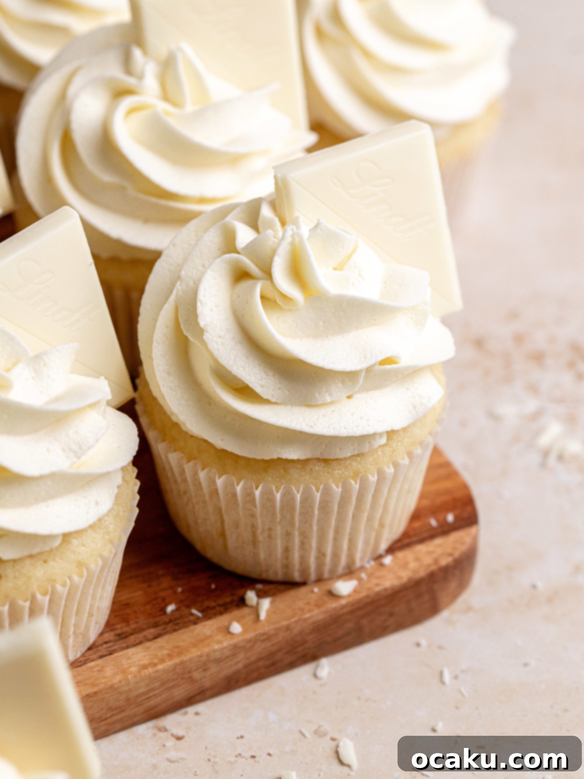 A perfectly frosted white chocolate cupcake with white chocolate shavings