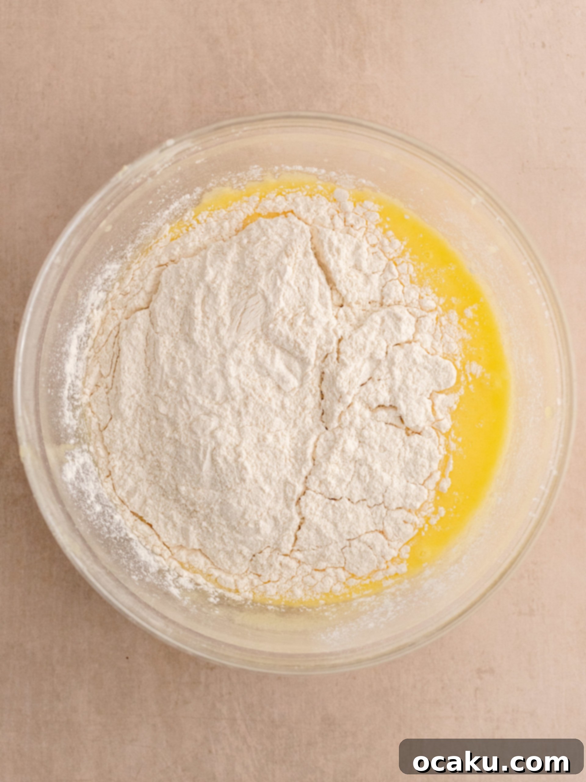 Step-by-step image of adding dry ingredients to cupcake batter