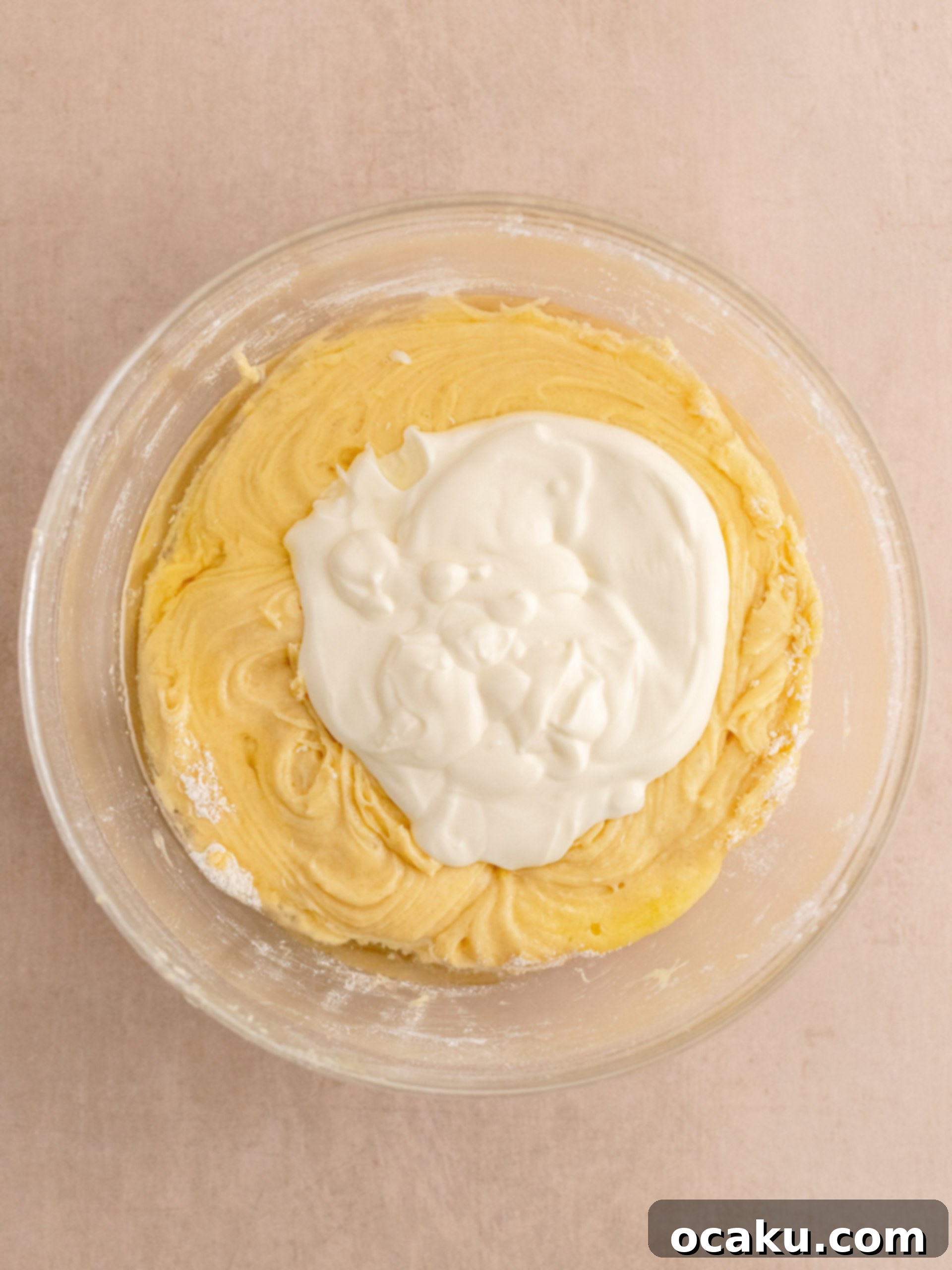 Step-by-step image of adding wet ingredients to cupcake batter