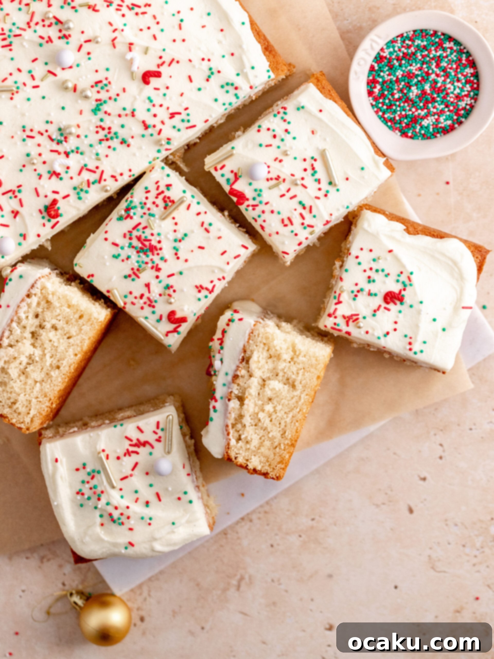 Cardamom cake cut into slices, showcasing its soft crumb and generous frosting.