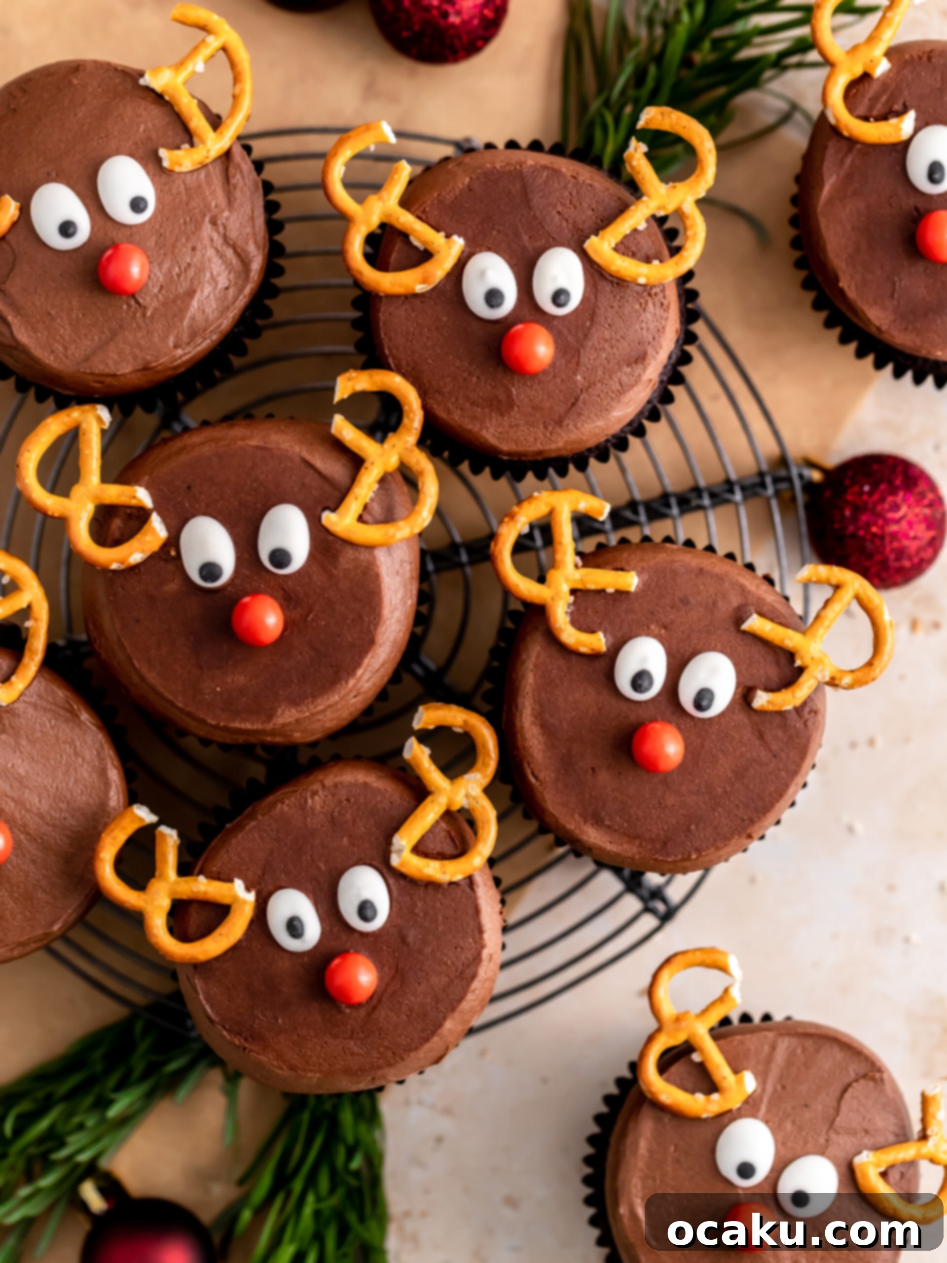 A festive display of decorated reindeer cupcakes on a serving tray, ready for a holiday party.