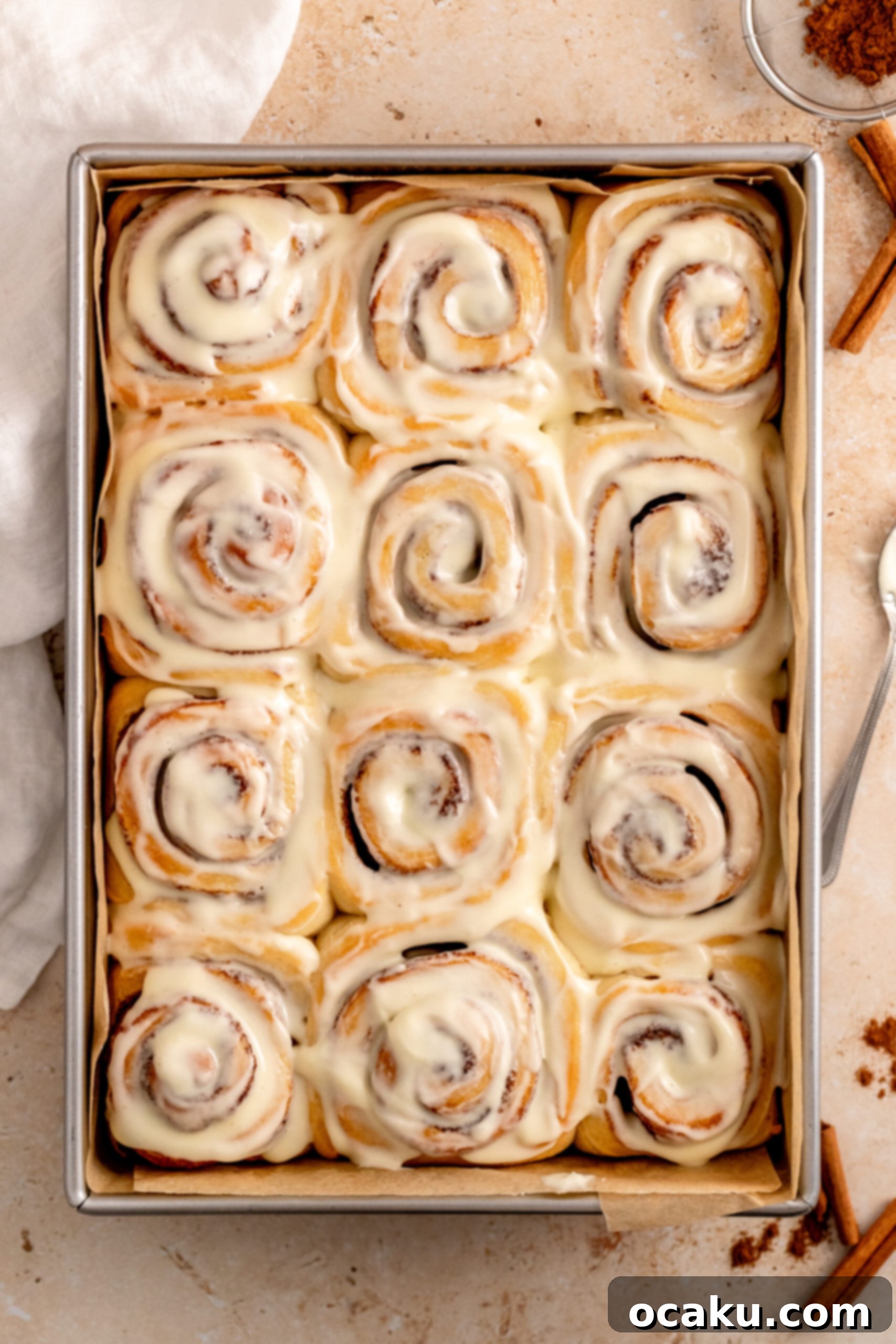 Freshly baked brioche cinnamon rolls topped with a generous layer of cream cheese frosting