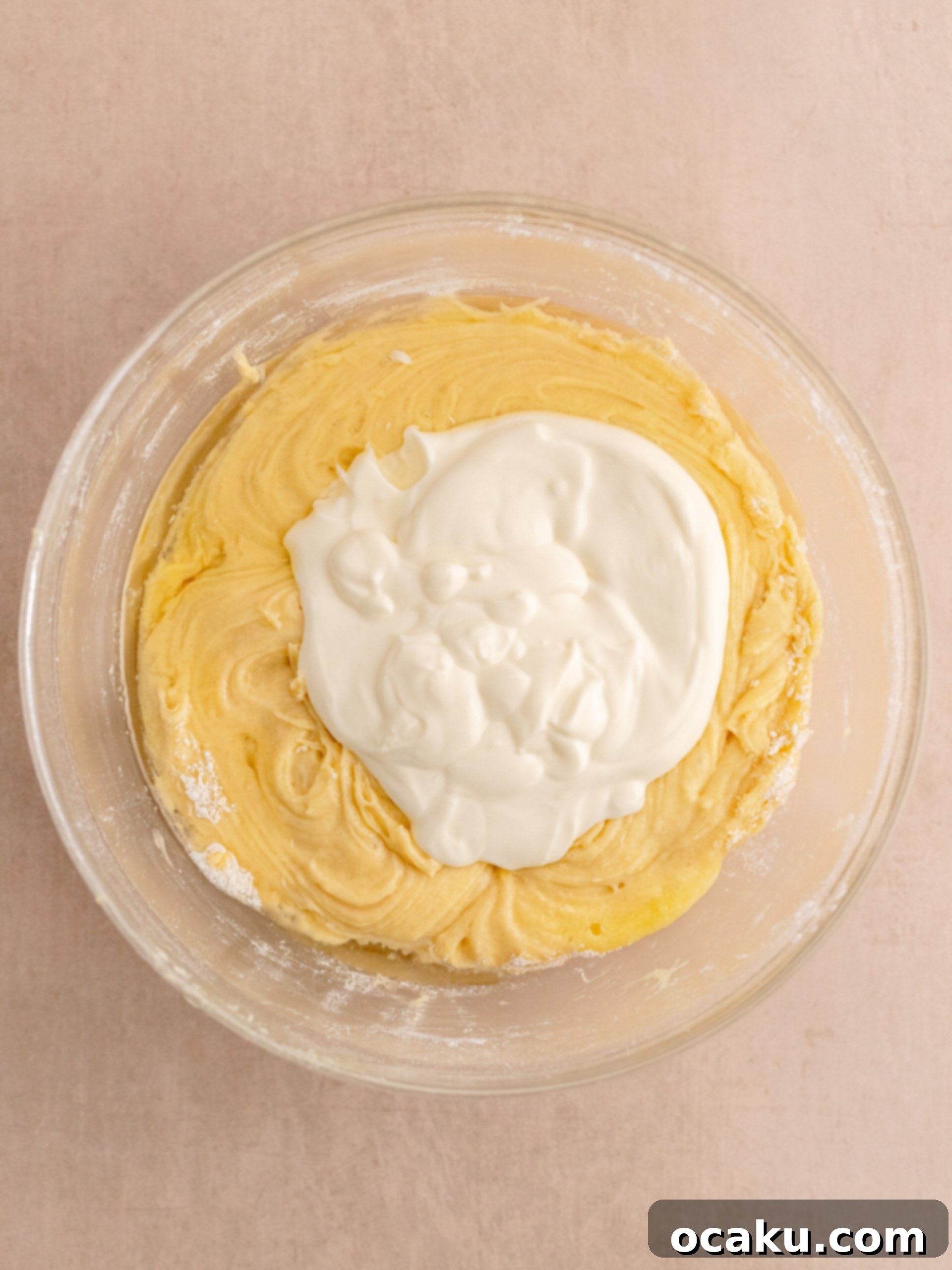 Cupcake liners filled with vanilla batter in a baking tray.