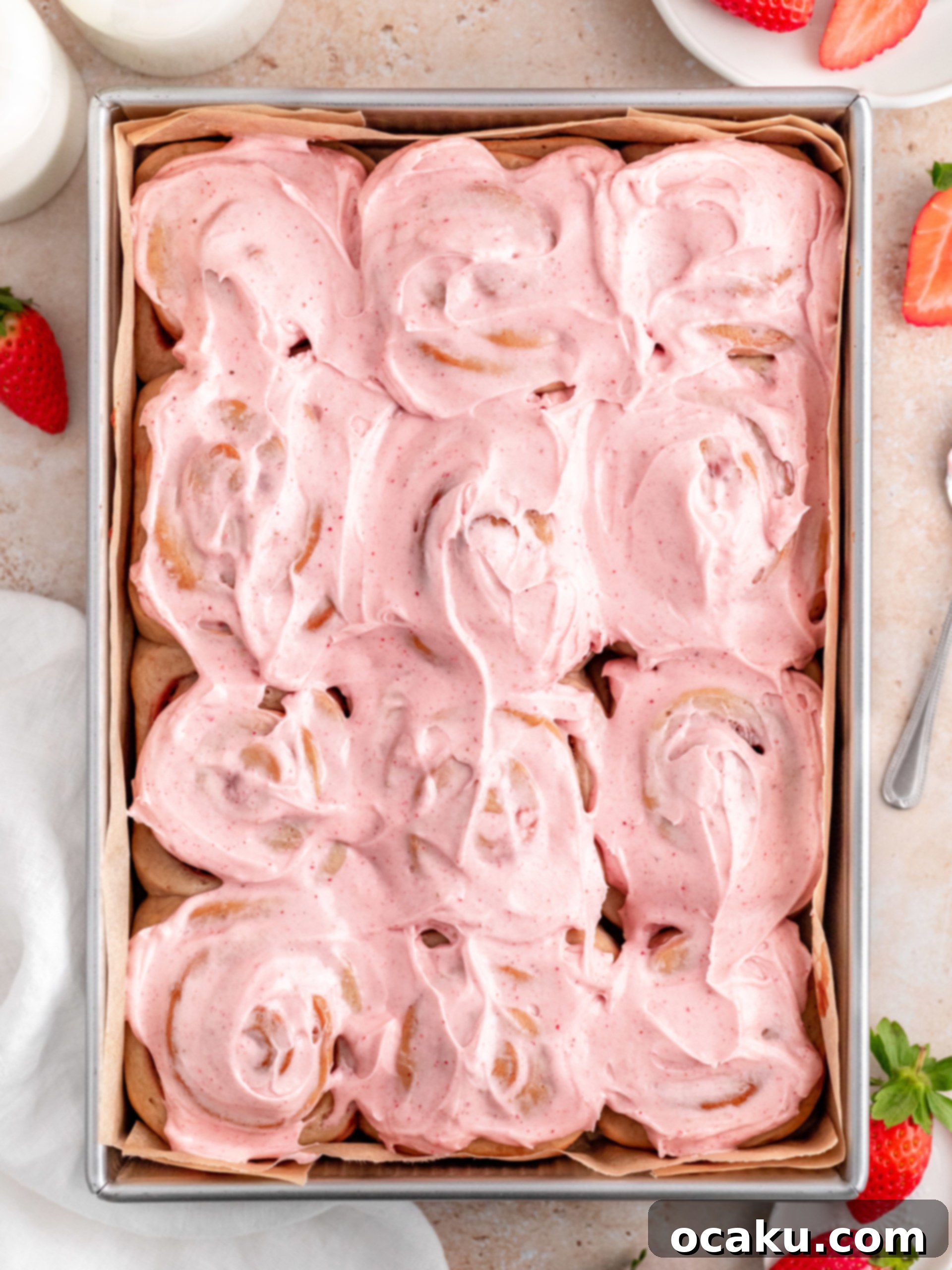 Freshly baked strawberry rolls, still warm, glistening with sweet frosting, ready to be enjoyed.
