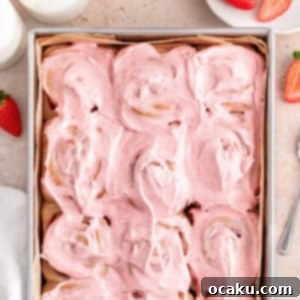 A close-up of a single beautifully frosted strawberry roll.