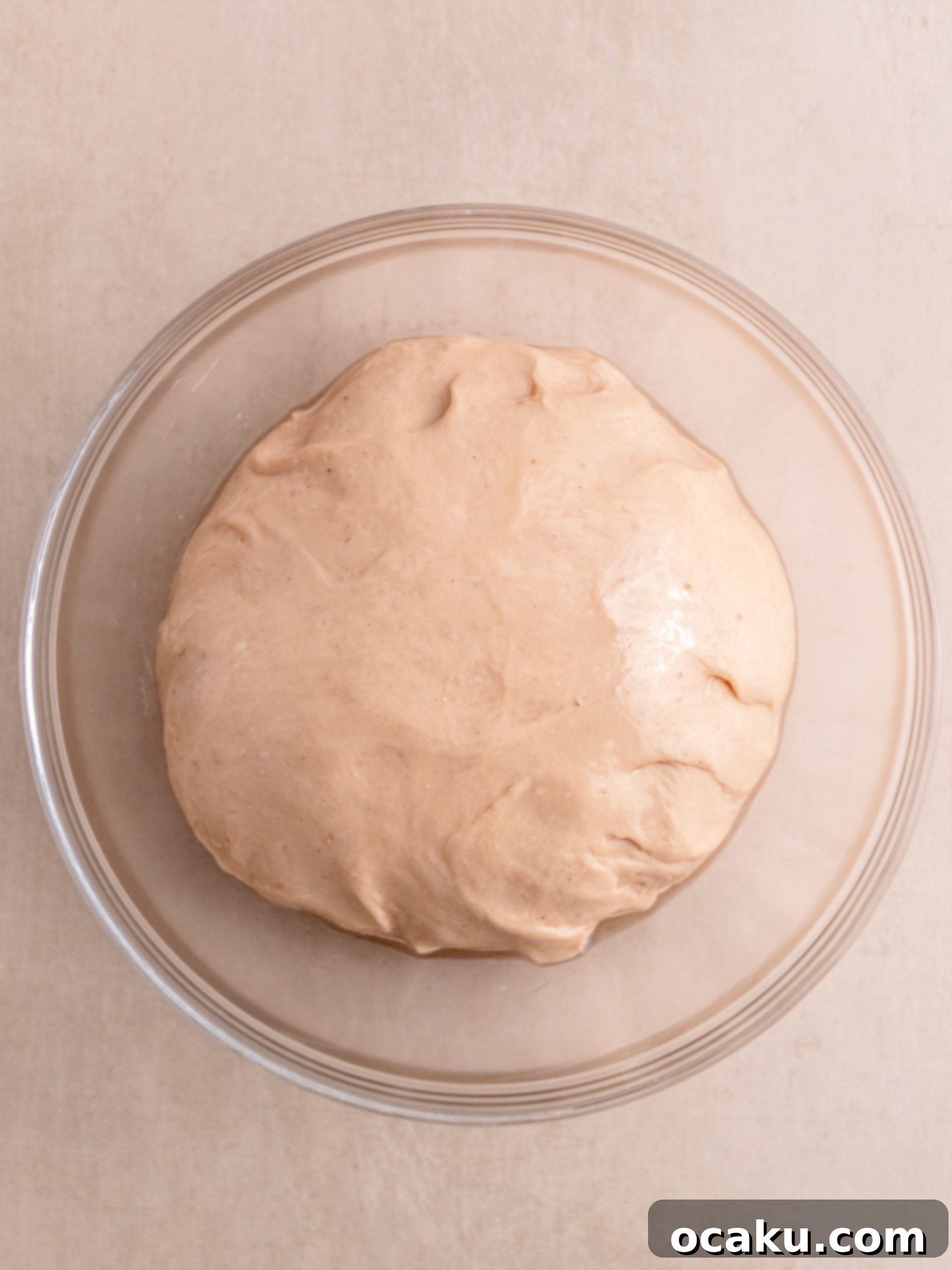 A large rectangle of strawberry-infused dough, evenly spread with luscious strawberry jam, ready to be rolled.