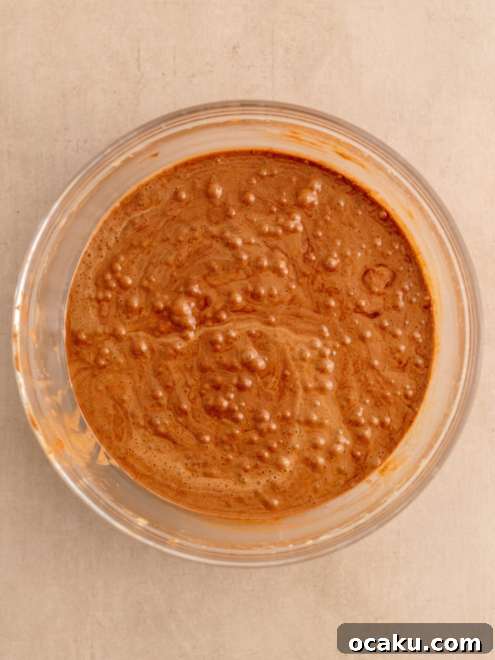 Mixing dry ingredients (flour, cocoa powder, cornstarch, salt) into the wet brownie batter.