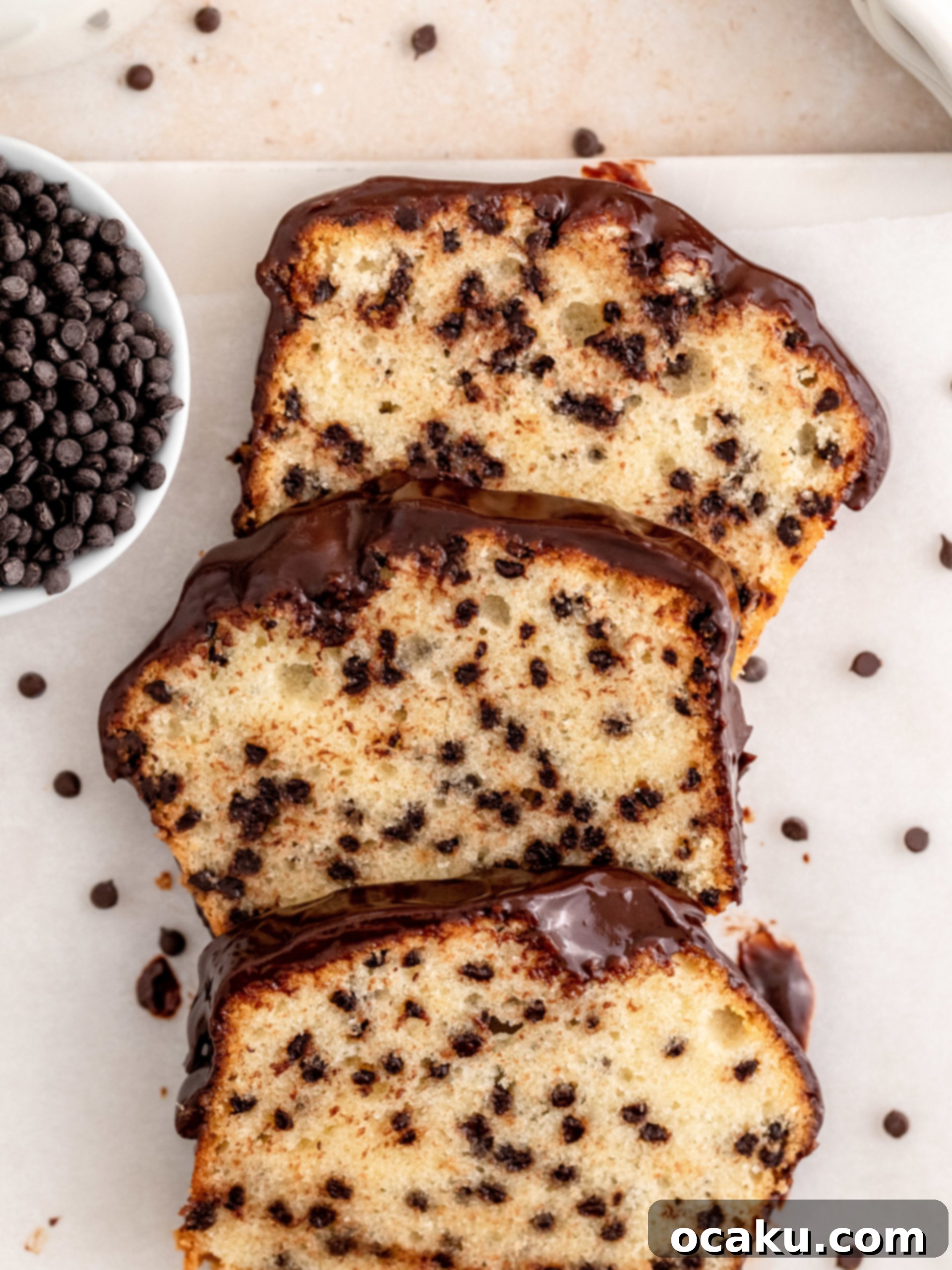 A perfectly sliced chocolate chip loaf cake on a serving board.