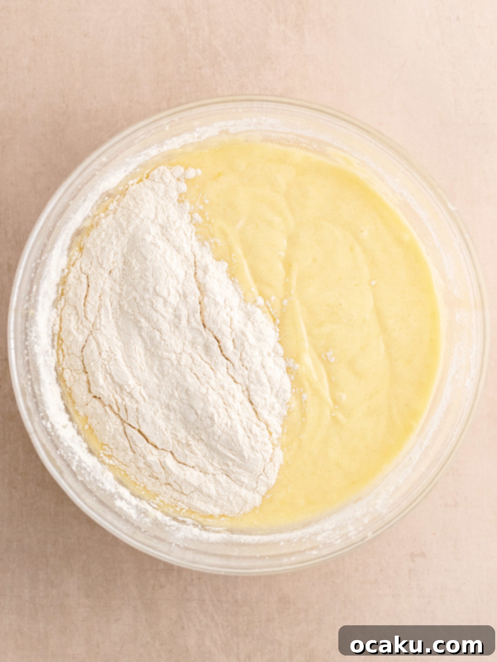 Sour cream, vegetable oil, and vanilla extract being added to the cake batter.