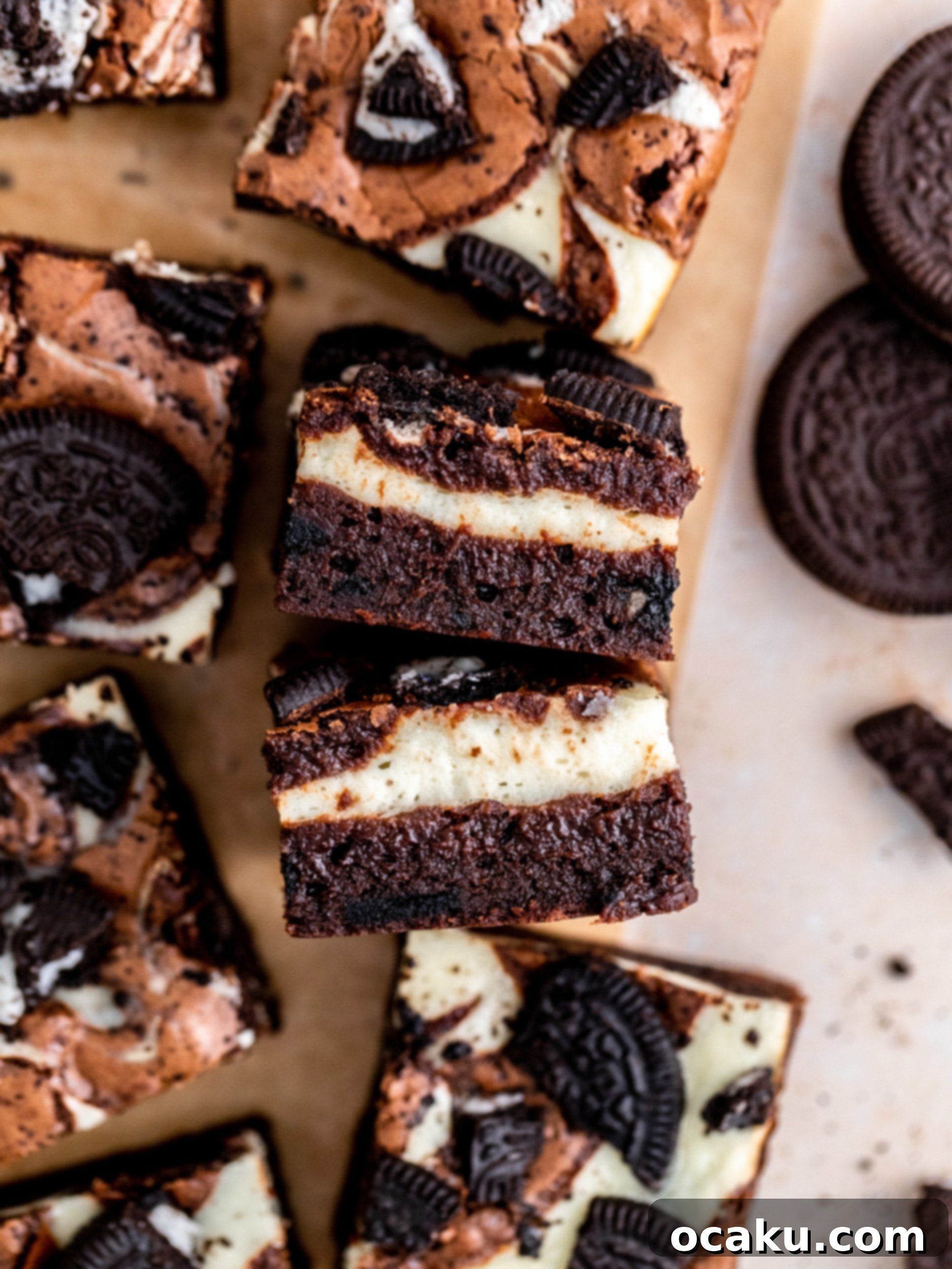 Close-up of a square Oreo Cheesecake Brownie, showing the distinct layers of brownie and cheesecake, and the crushed Oreos on top.