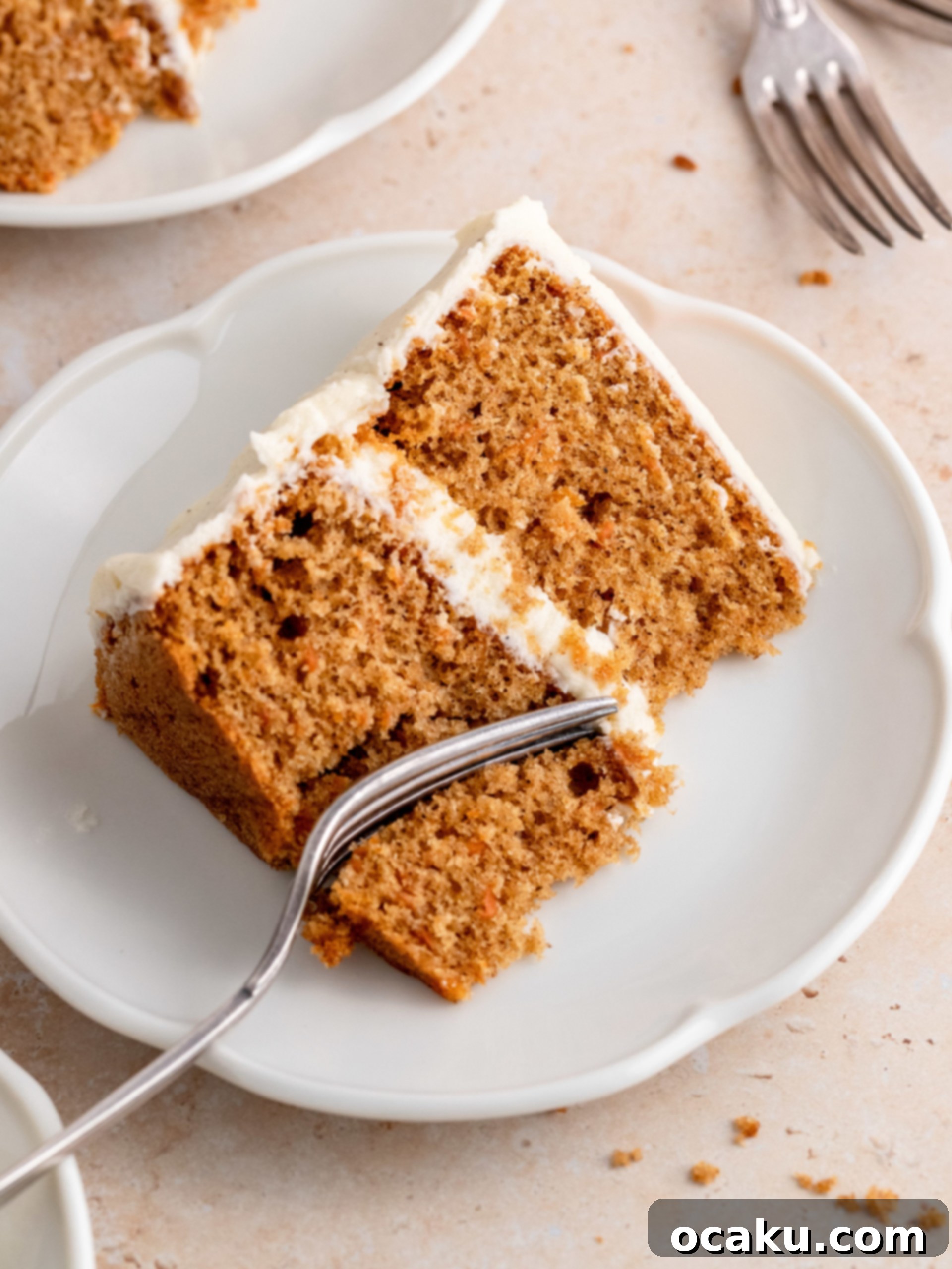 A close-up of a beautifully decorated mini carrot cake, showcasing the textured cream cheese frosting and piped carrot details.
