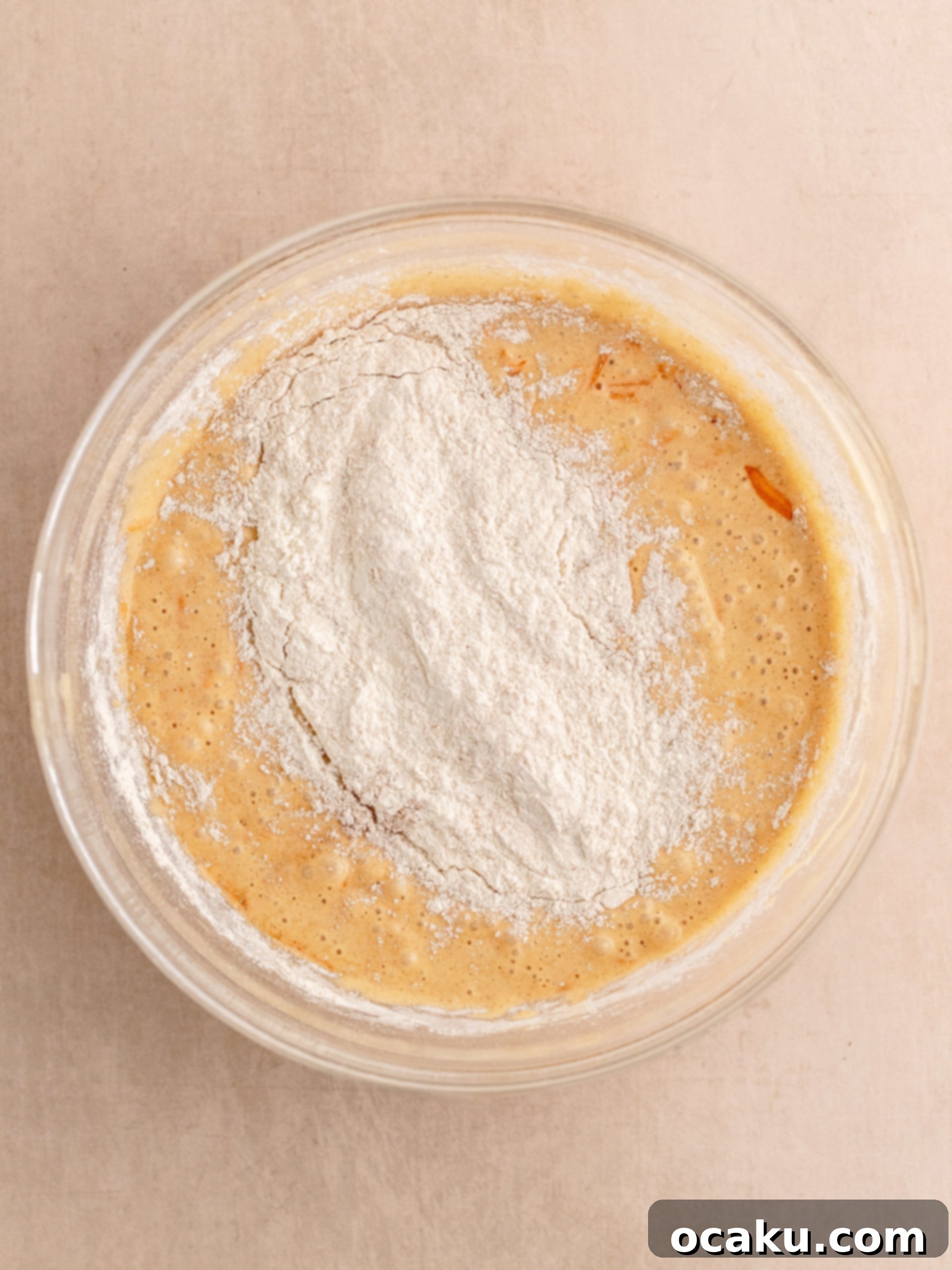 Dry flour mixture being gently folded into the wet batter.