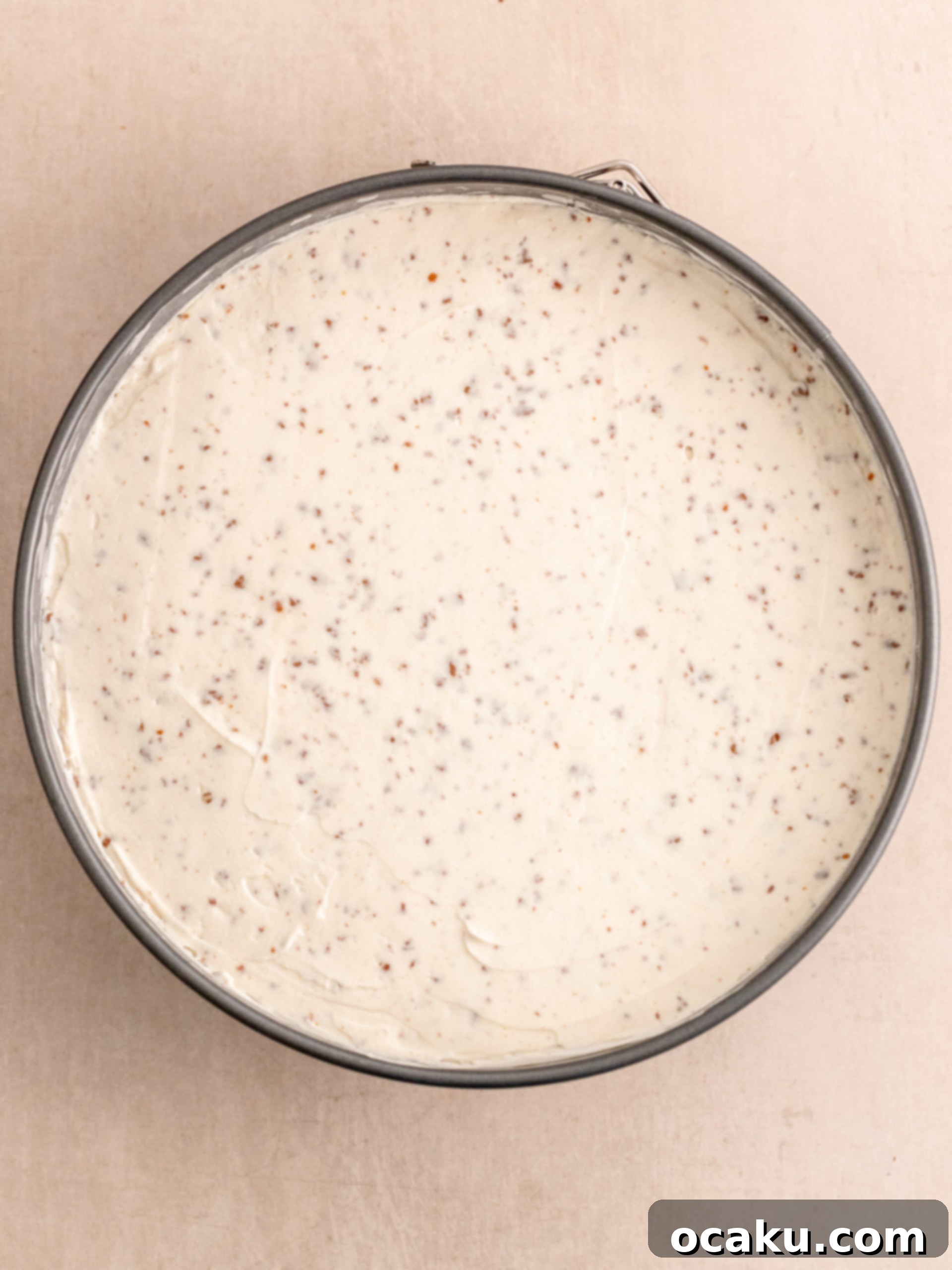 Milk chocolate ganache being poured over the chilled cheesecake.