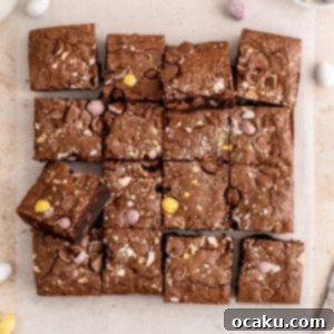 A top-down shot of a square of Mini Egg Brownie, showcasing the fudgy center and crunchy egg pieces, ready to be enjoyed.