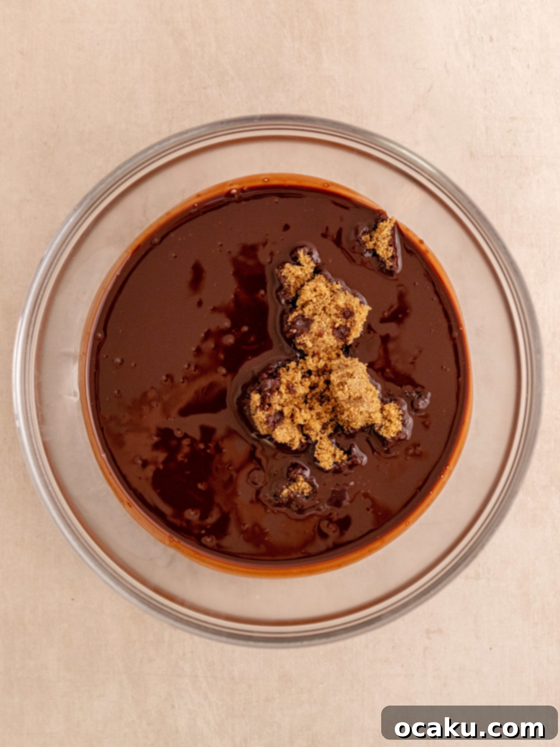 Close-up of brownie batter being mixed in a bowl, showing the smooth, dark chocolate consistency.