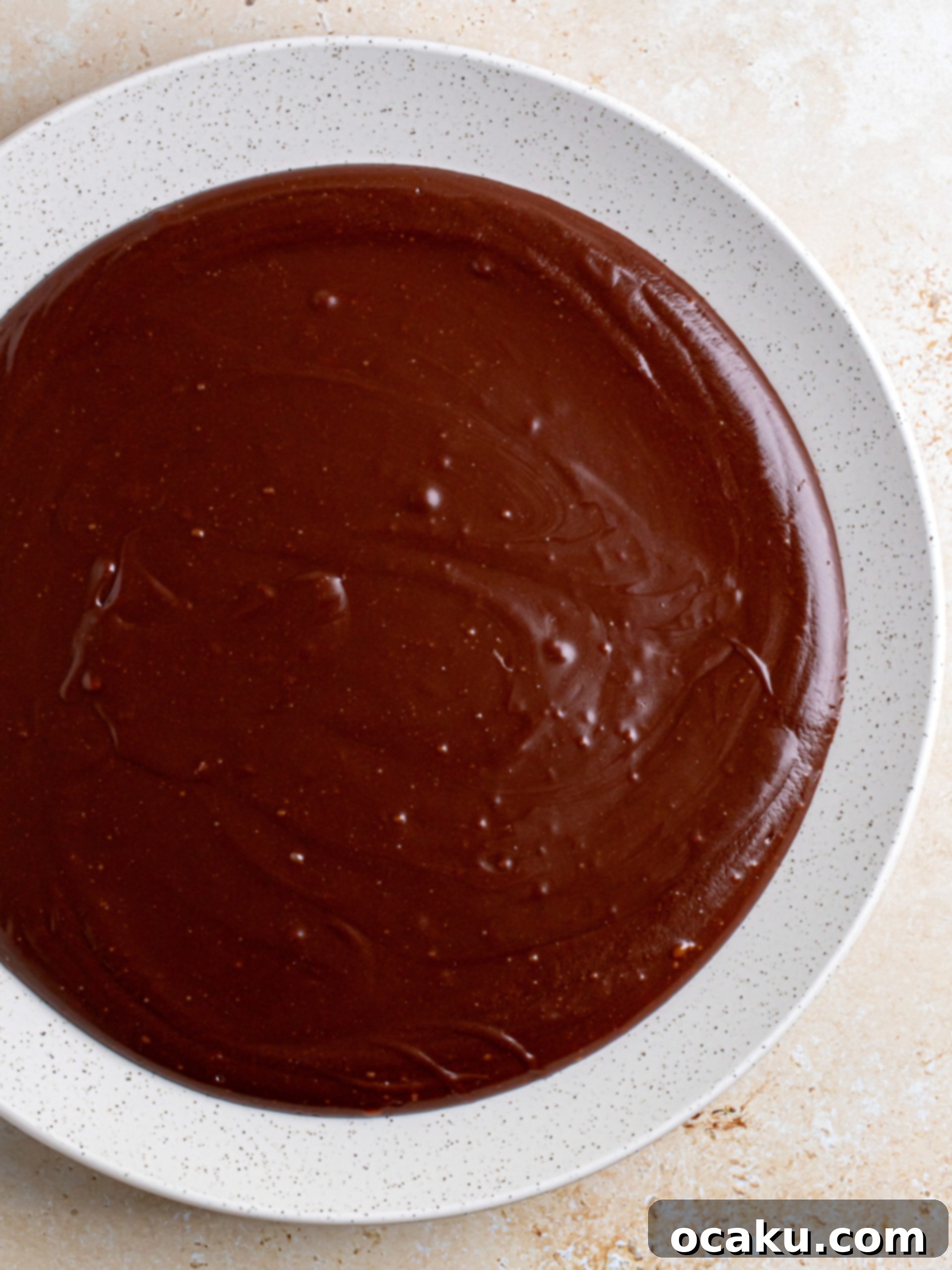 Fudge frosting ingredients melting in a saucepan on the stove.
