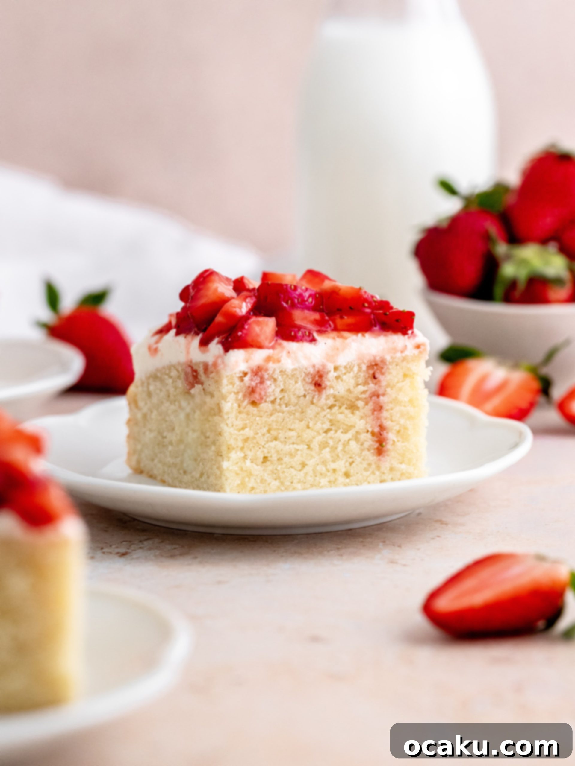 A freshly baked Strawberry Vanilla Cake, topped with creamy vanilla buttercream and bright red strawberries.