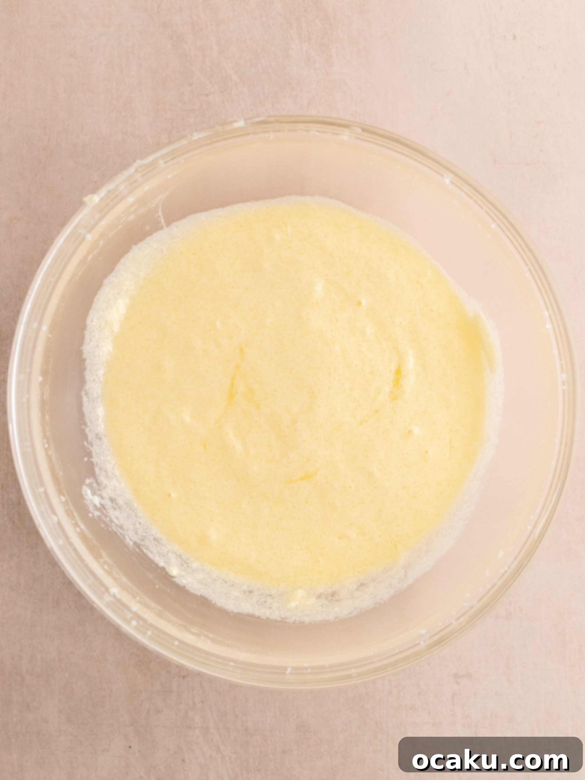 Adding eggs one by one to the creamy mixture.