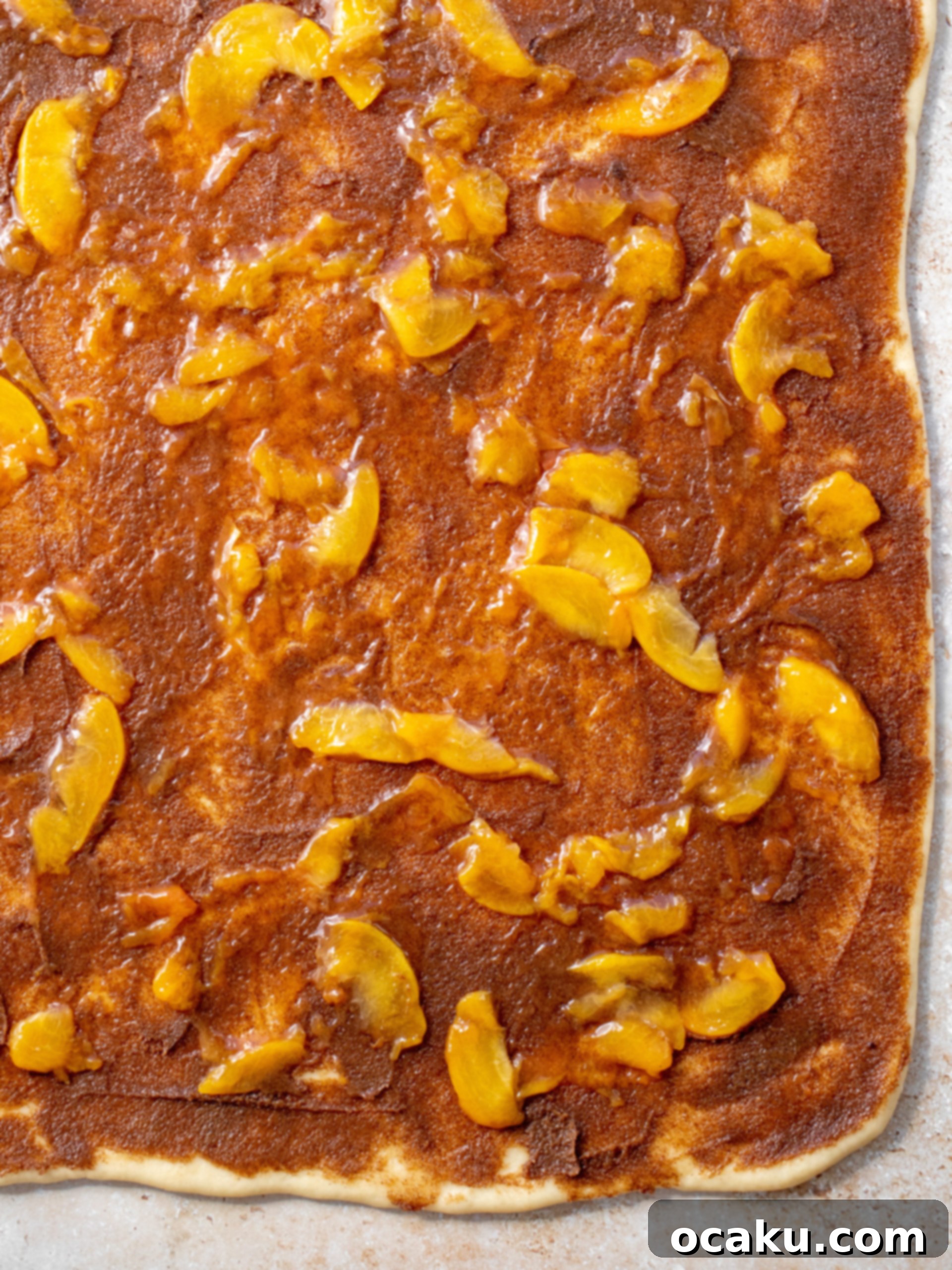 the dough rolled out with the cinnamon filling and peach jam spread out. 