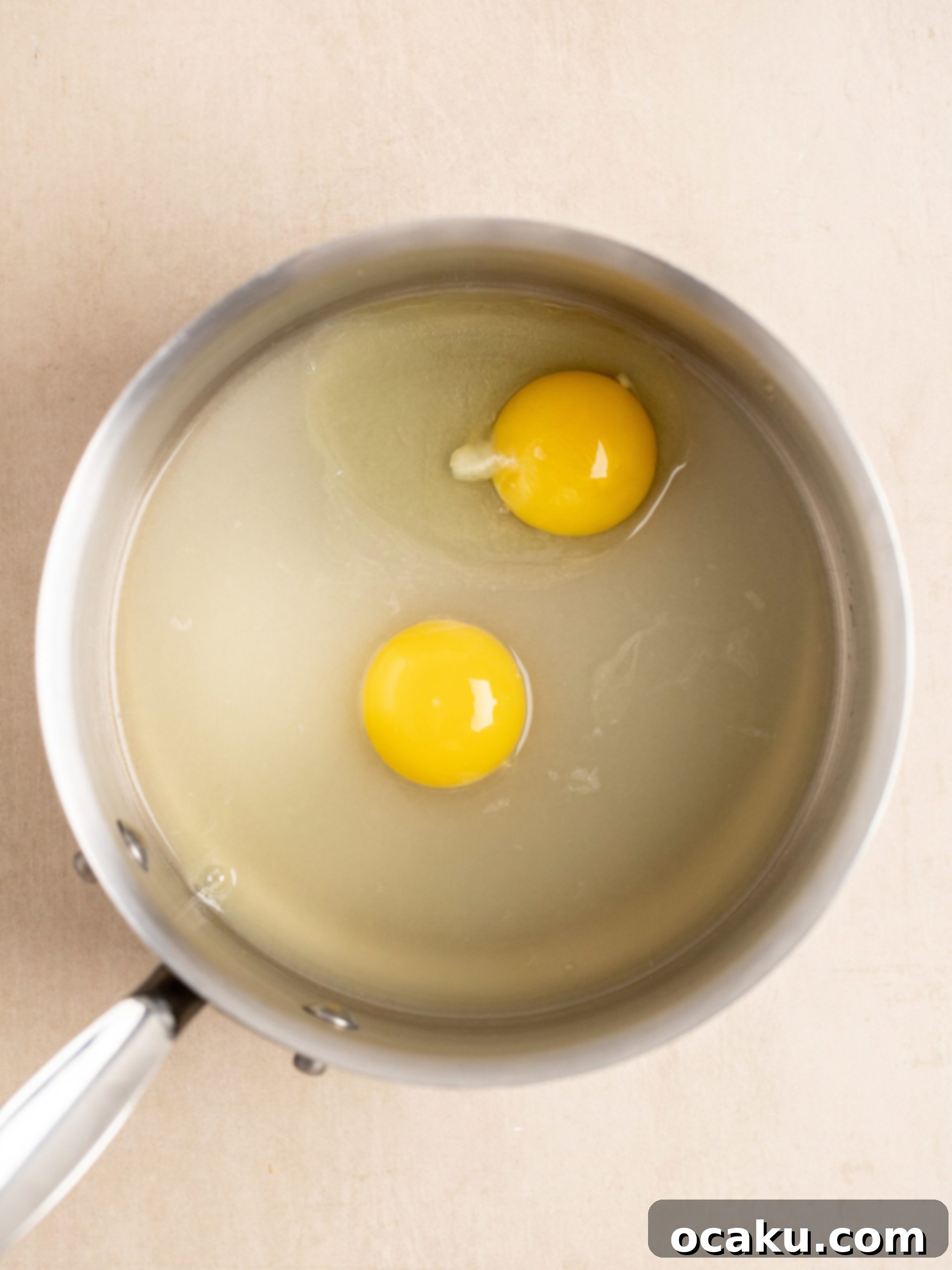 Lemon curd mixture in a saucepan, being whisked
