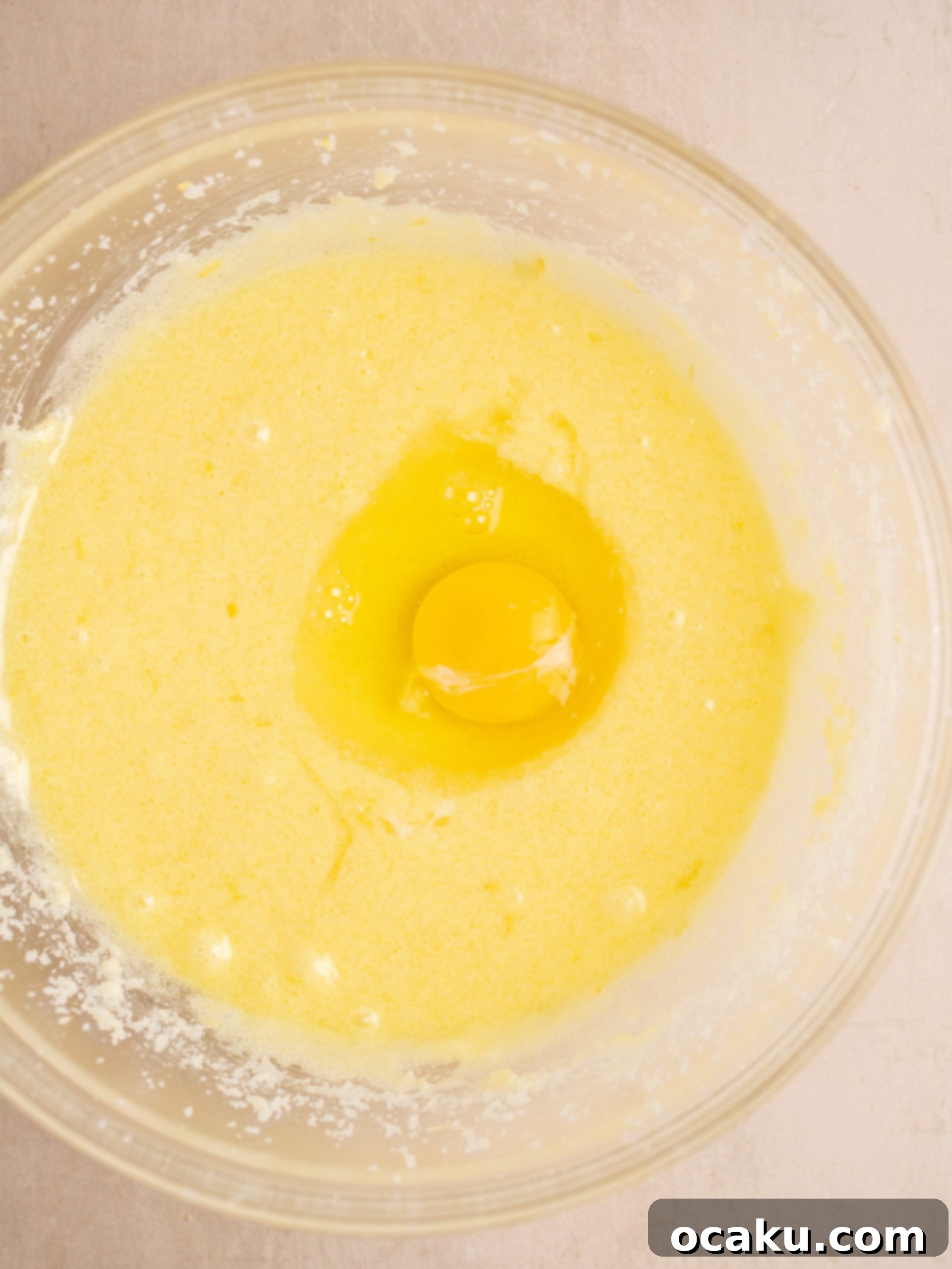 Adding eggs one by one to the cake batter