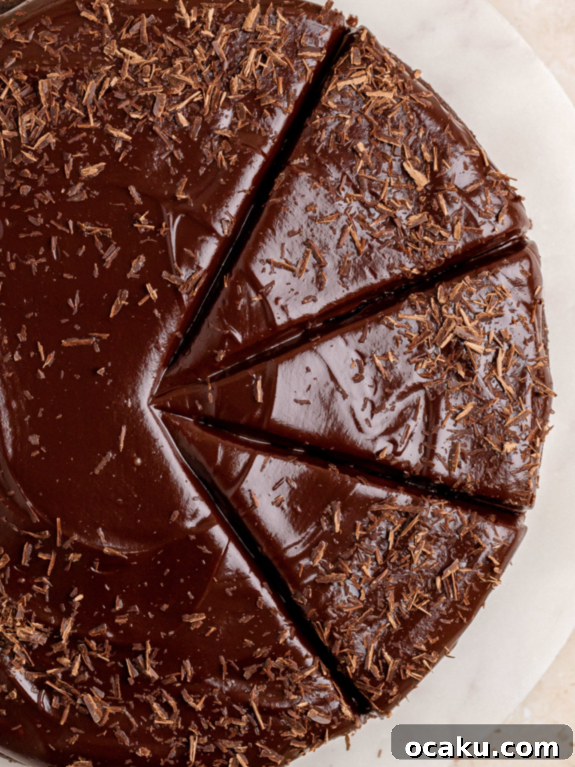 A close-up shot of the perfectly smooth and glossy chocolate ganache frosting on a cake.