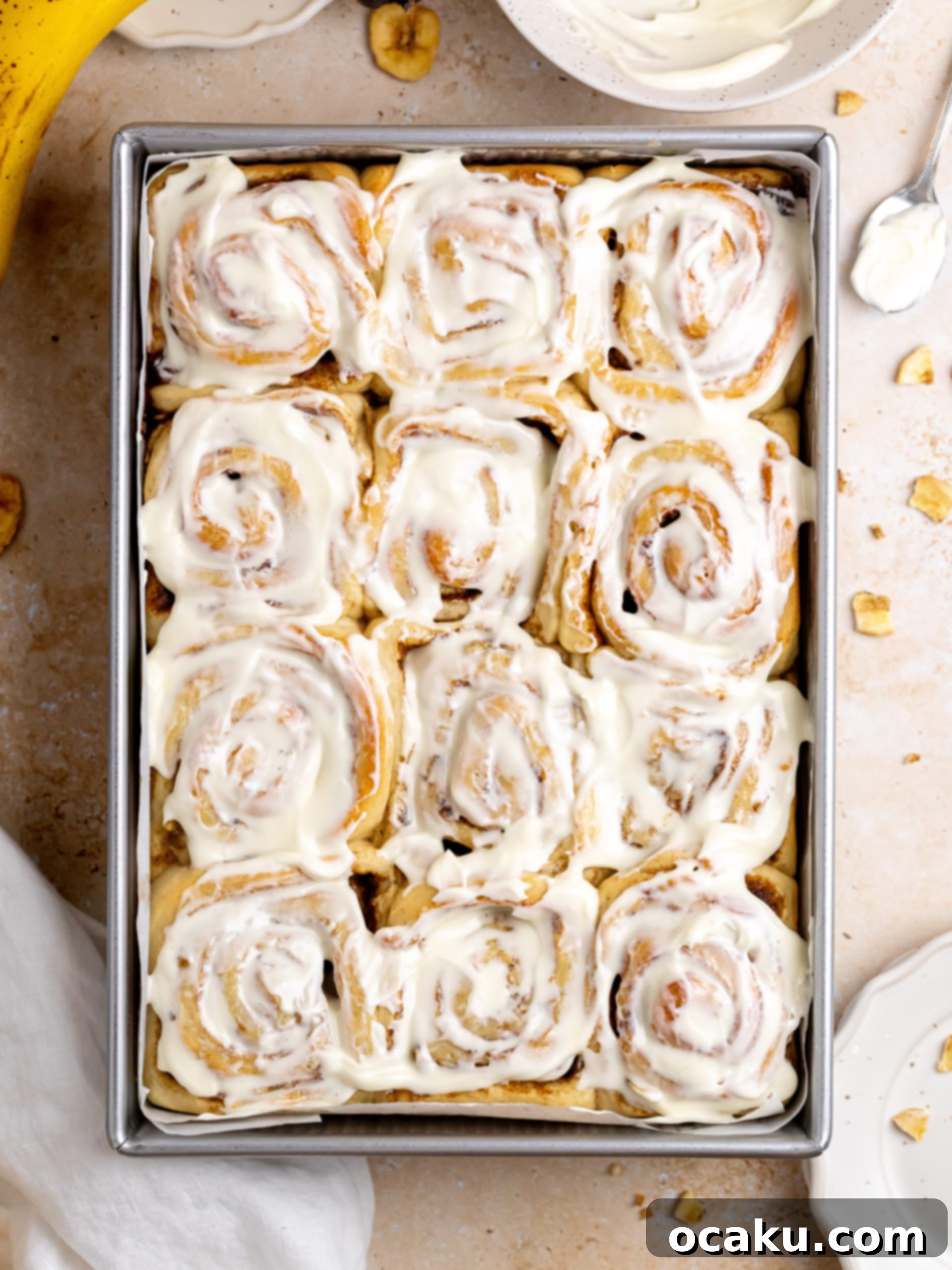 Freshly baked Banana Cinnamon Rolls with cream cheese frosting, ready to be served.