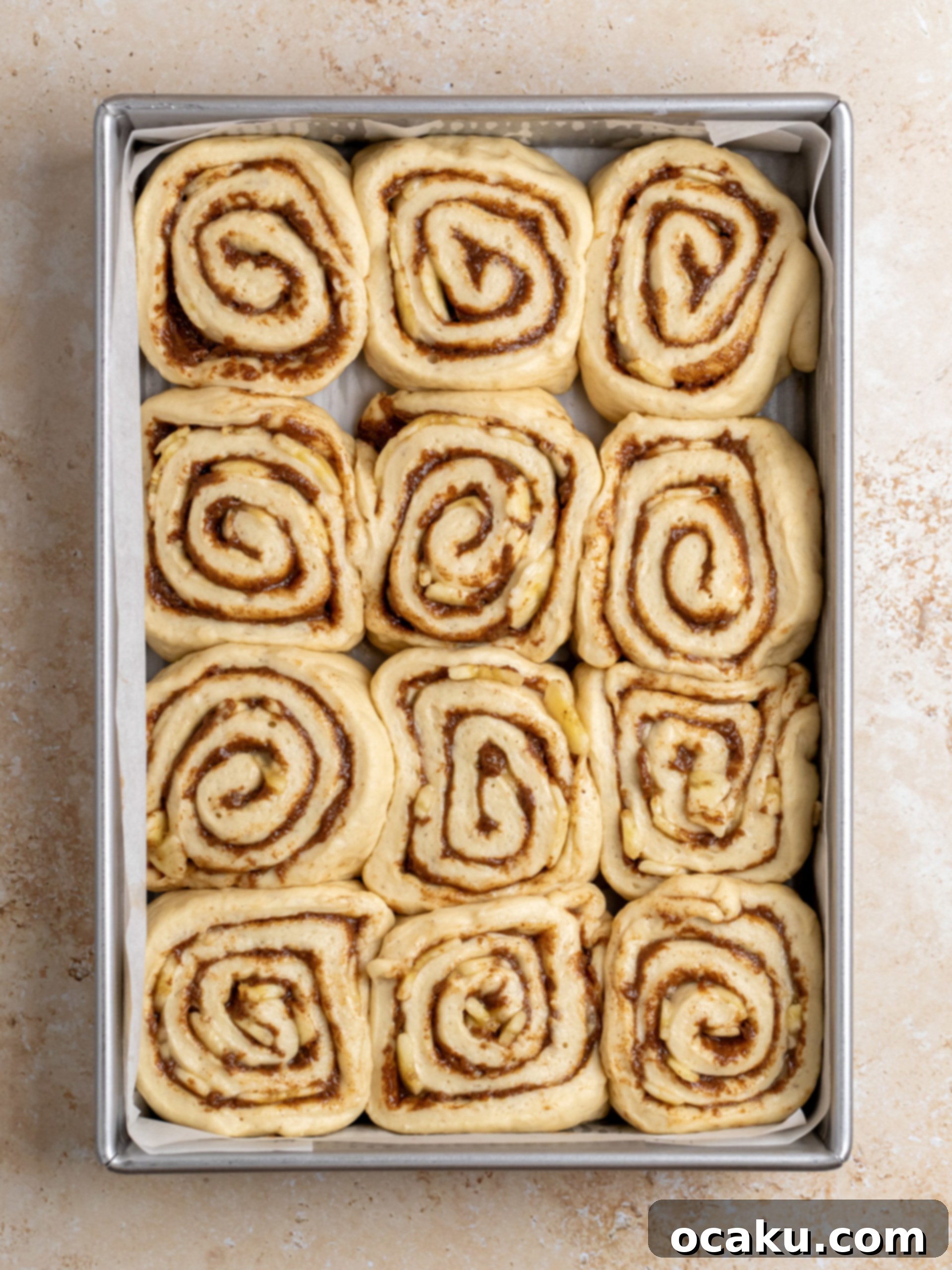 Image of cinnamon and banana filling spread on dough.