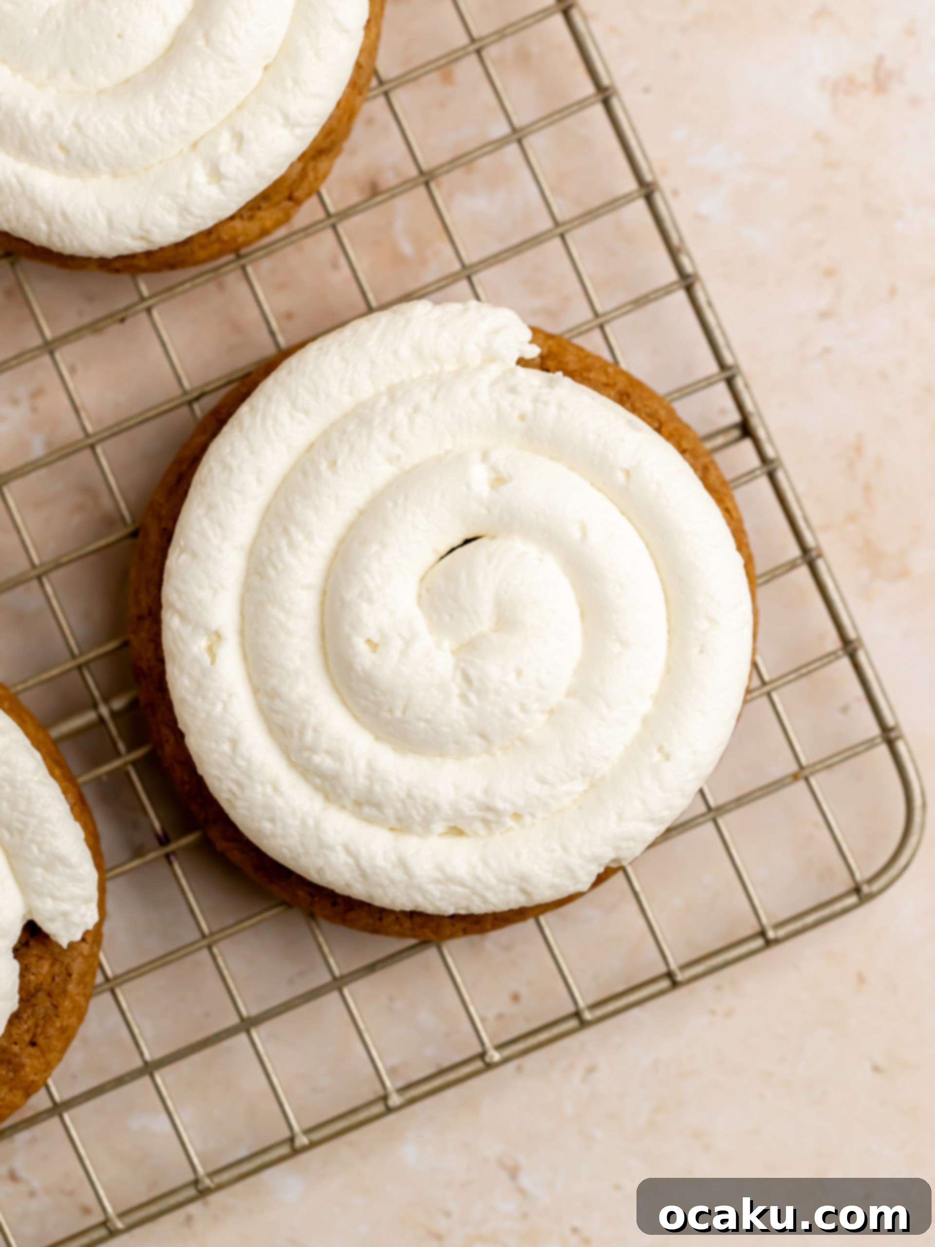 Coffee Mascarpone Cookies 10 Mascarpone cream piped onto multiple cookies on a tray.