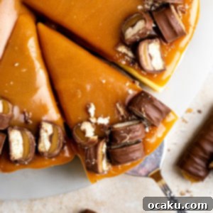 Twix Caramel Cheesecake 14 A slice of rich Twix Cheesecake with caramel and candy pieces.